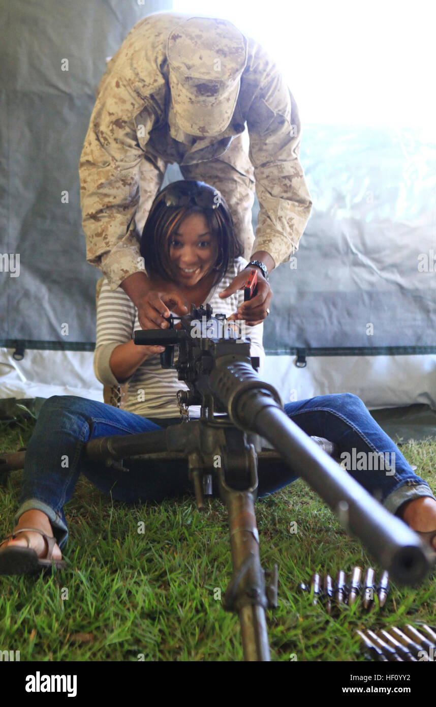 Cpl. Darius Jenkins, a motor vehicle operator with Combat Logistics Battalion 6, 2nd Marine Logistics Group, demonstrates how to operate the .50-caliber machine gun to his wife, Erica Jenkins, during the unit’s Jane Wayne Day activities aboard Camp Lejeune, N.C., Sept. 12, 2012. The event’s activities helped the spouses and families of the Marines gain a greater understanding of the daily responsibilities of their servicemembers while giving them hands-on experience with the unit’s equipment. Jane Wayne Day puts Marine spouses on the firing line 120912-M-ZB219-030 Stock Photo