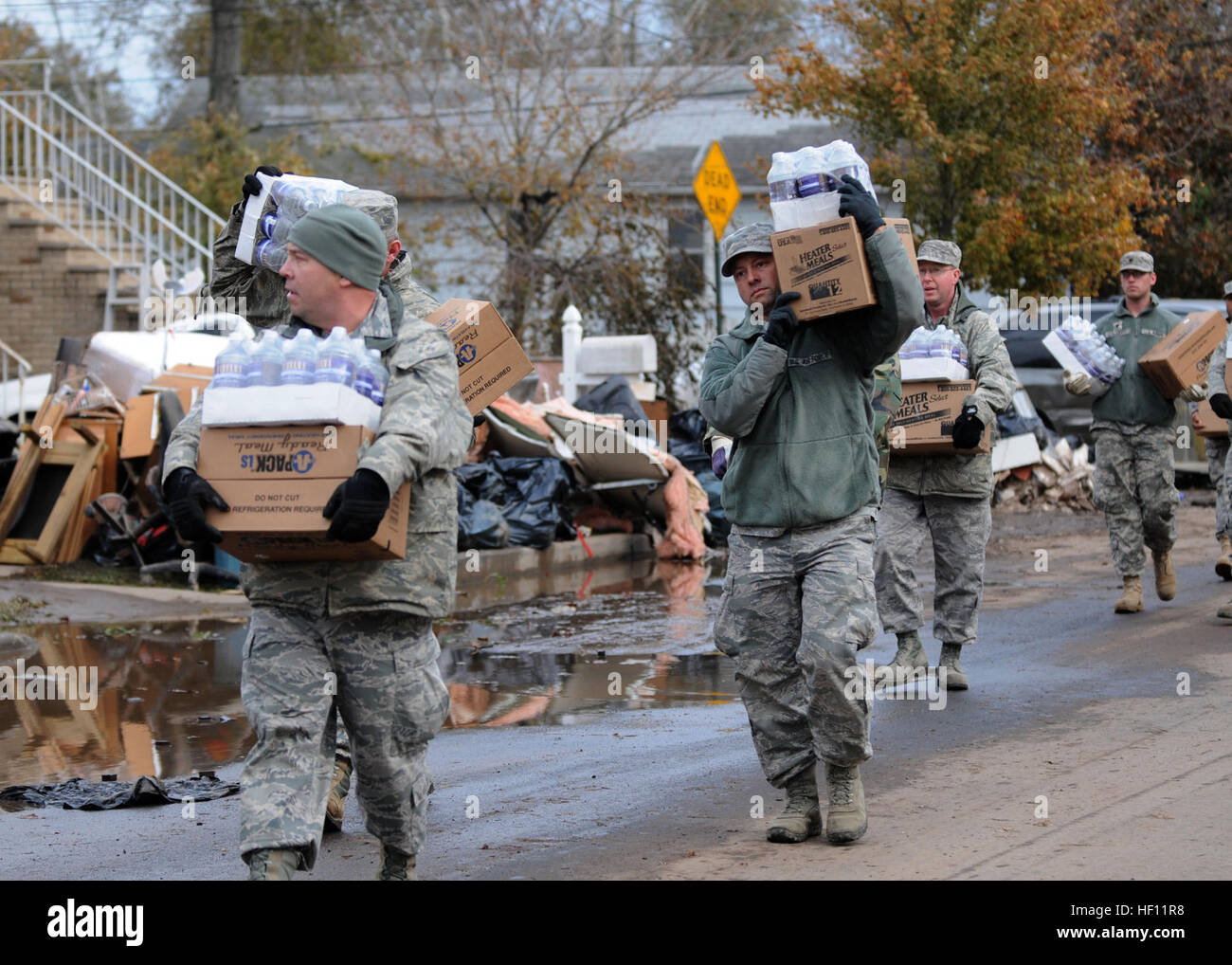 New York Air National Guard Master Sgt. Thomas Moade from the 174th Attack Wing out of Syracuse leads other members of the 174th as well as members of the New York Army Guard from Newburg in taking water and cases of food to local residents in Staten Island on 2 November 2012. The food and water was provided to people who needed assistance after hurricane Sandy took down power lines and caused massive destruction to many homes in the area leaving families desperate for help. Moade and the others were taking the food to those who could not make it to the Emergency Response location. (New York A Stock Photo