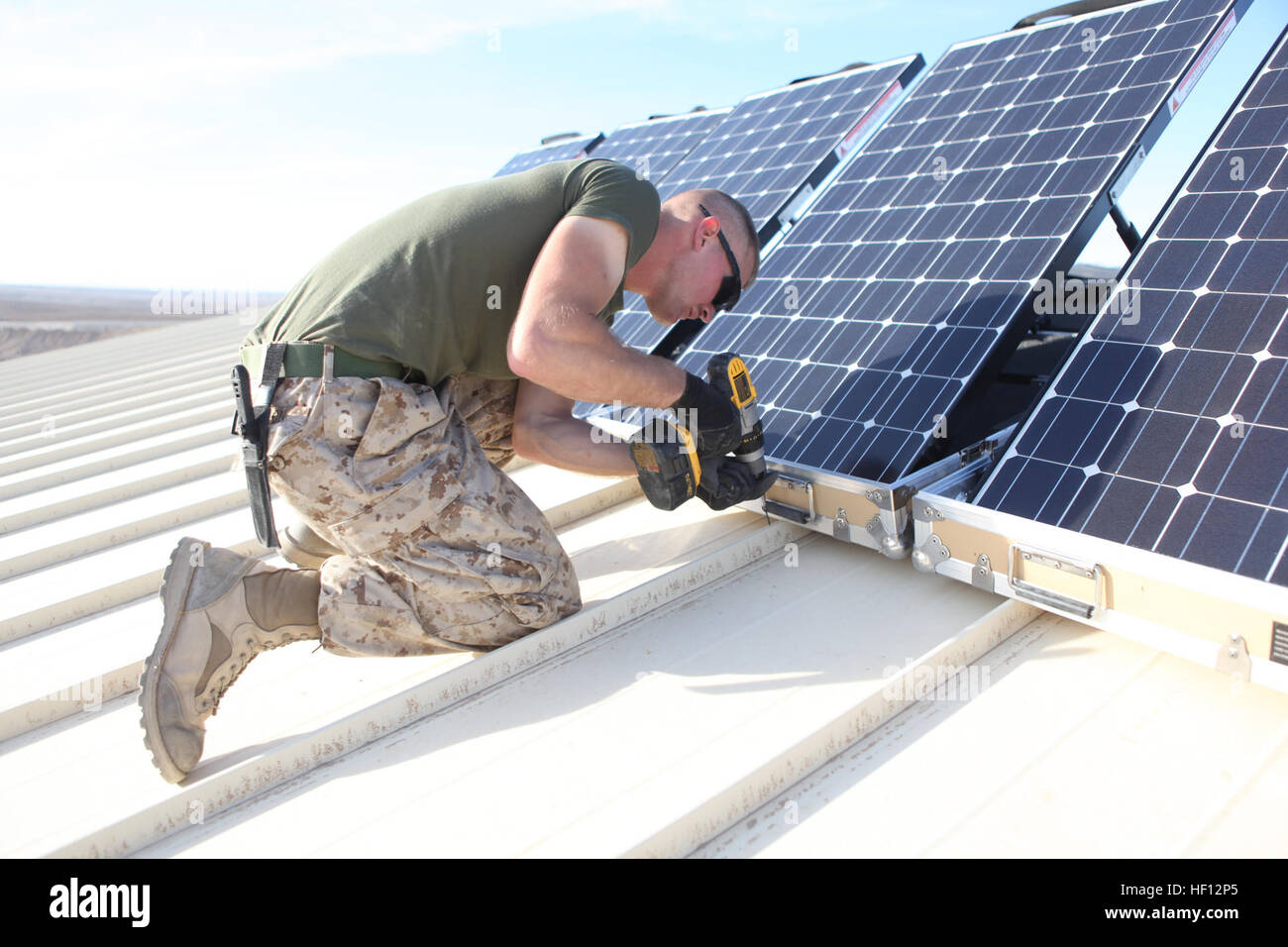 U.S. Marine Corps Cpl. Robert G. Sutton, left, and Cpl. Moses E. Perez, field wireman with Combat Logistics Regiment 15 install new solar panels on Combat Outpost Shukvani, Helmand province, Afghanistan, Nov. 19, 2012. Sutton and Perez installed the solar panels to provide power to radios, laptops, and computers in the event of power outages.(U.S. Marine Corps photo by Lance Cpl. Alexander Quiles/Released) Solar Panel installment 121119-M-SF473-014 Stock Photo