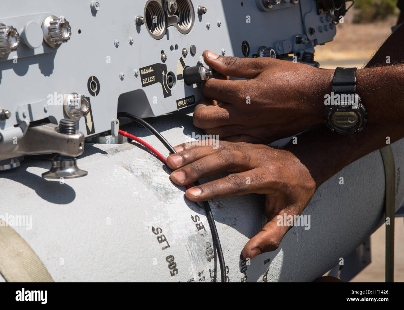 An aviation ordnance Marine with Marine All-Weather Fighter Attack Squadron (VMFA(AW)) 225 "Vikings" locks in place a MK-82 low-drag bomb on an F/A-18 ...
