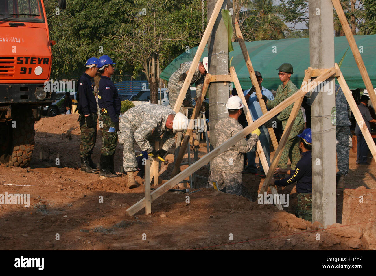 Singapore, Thai and U.S. service members center and stabilize the second pillar for a new school structure during a pillar-raising ceremony Jan. 22 at Ban Hua Wang Krang School, Maung District, Phitsanulok province, Kingdom of Thailand. The construction is part of several ongoing engineering civic assistance projects leading up to the commencement of Exercise Cobra Gold 2013. Singapore service members are with Singapore Combat Engineers. Thai service members are with the Mobile Development Unit 34, Development Command, Royal Thai Army. U.S. service members are with the 643rd Engineer Company ( Stock Photo