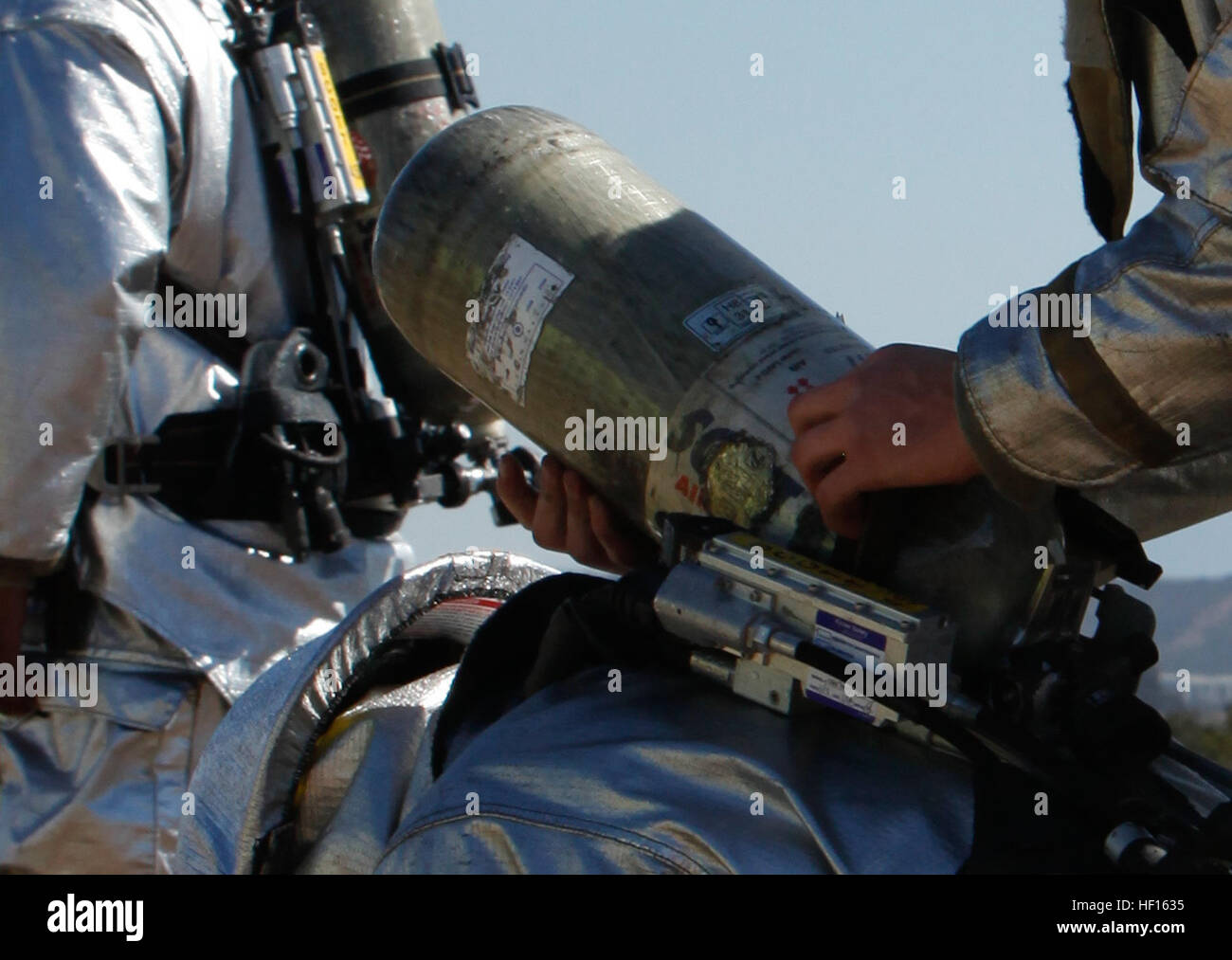 A Marine with Aircraft Rescue and Firefighting helps another Marine ...
