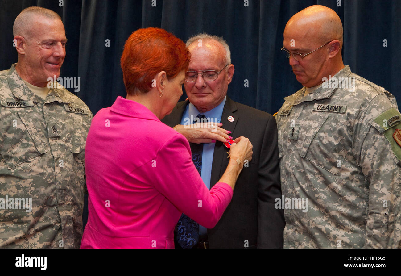 Army Maj. Gen. Karl R. Horst. U.S Central Command chief of staff  Army Command Sgt. Maj. Frank A. Grippe, USCENTCOM senior enlisted leader, watch as Kaye French presents her husband, Army Sgt. Robert French, a Bronze Star Medal March 5 for his actions during the Vietnam War in 1967.  French served with the Mobile Riverine Forces, which was based on Navy ships in the South Vietnam Mekong Delta.  His award comes 46 years after retired Army Capt. Jack Benedick, French's platoon commander at the time, nominated him and four others for the award.    (USCENTCOM photo by Sgt. Fredrick J. Coleman) CEN Stock Photo