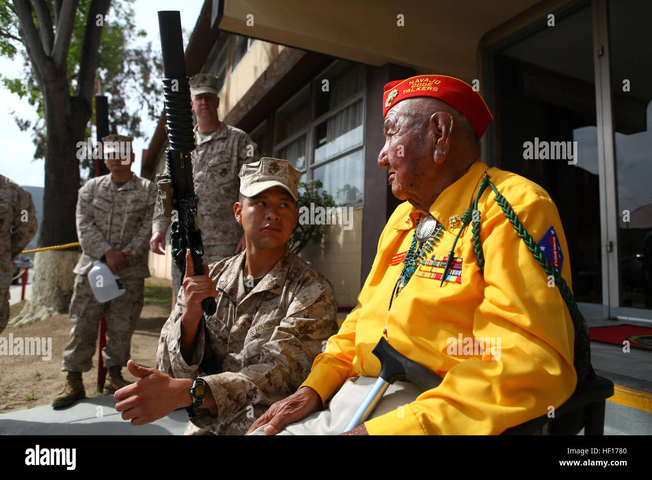 Lance Cpl. Nicholas Kien, a rifleman serving with 2nd Battalion, 5th Marine Regiment, shows Samuel Tsosie, a retired Marine who served as a Navajo Code Talker during World War II, an M16 service rifle here at Camp San Mateo, March 27, 2013. Tsosie's visit to the battalion gave some of the younger Marines an opportunity to learn about an important aspect of the Corp's heritage. Tsosie served with 2nd Bn. 5th Marines, in multiple battles including Peleliu, Okainawa, and Cape Gloucester. Navajo Code Talker visits at old stomping grounds 130327-M-GO800-016 Stock Photo