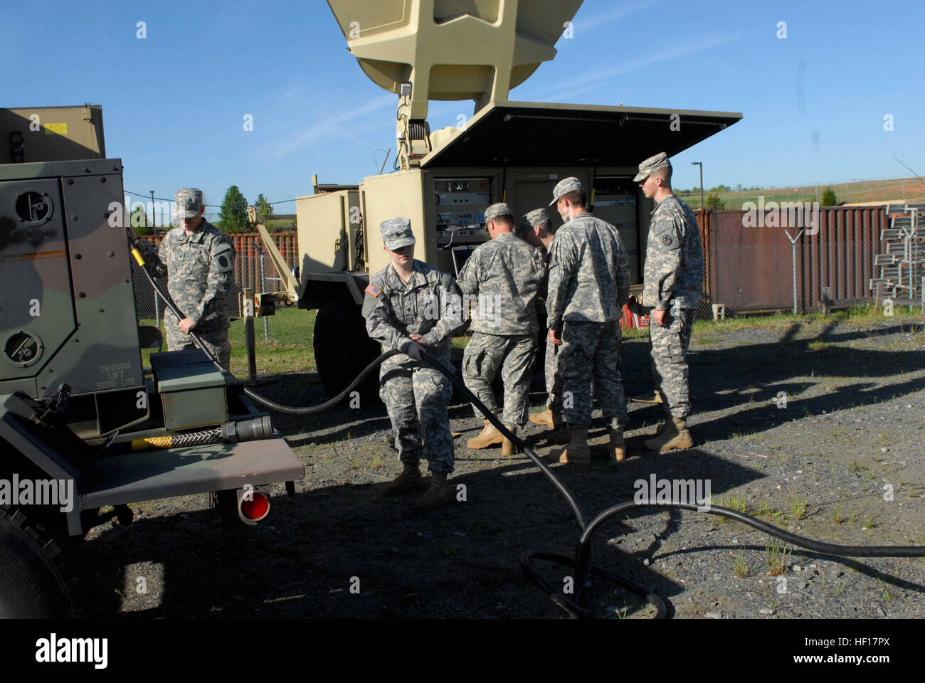 North Carolina National Guard Army Spc. Megan Blue (middle) pulls the generator power cord and Army Spc. Erik Van Dyne (left) connects it to the Joint Network Node as they test equipment during the 295th Signal Network Support Company's preparation for annual training, April 13. Van Dyne and Blue manned the node station during the training, making sure the internet and phones received connection. Blue received instructions from Van Dyne who entered the military about three years ago without any computer knowledge and was told to enter this military occupation based on his entrance test scores. Stock Photo