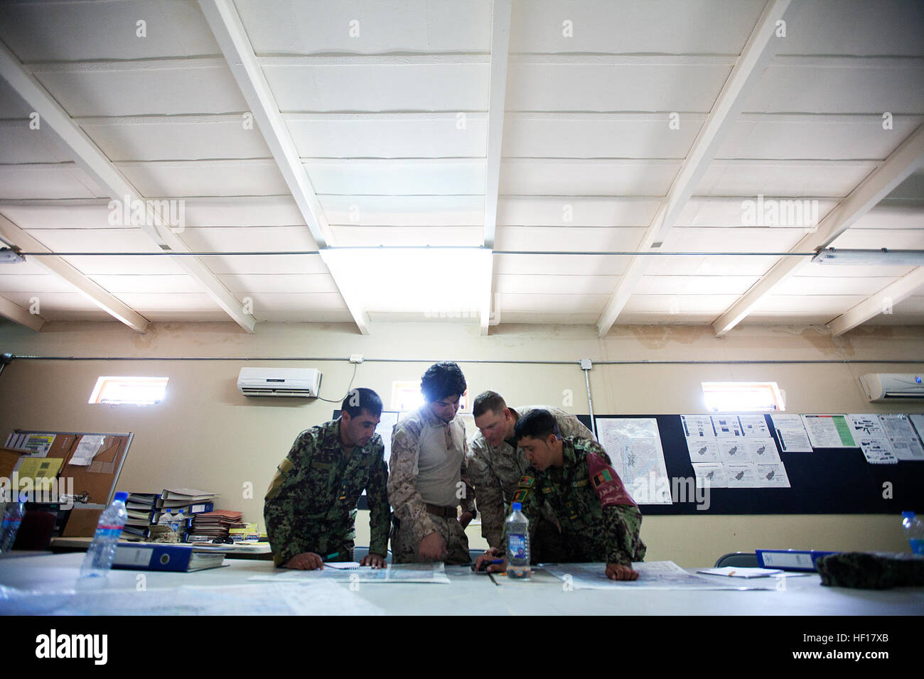 U.S. Marine Corps 1st Lt. Thomas Cutsinger, center right, an instructor with the Regional Corps Battle School (RCBS), Regional Command (Southwest), teaches map reading skills to Afghan National Army soldiers during a class at Camp Shorabak, Afghanistan, April 16, 2013. RCBS instructors provide guidance to coalition forces on topics such as tactical driving, navigation, weapons systems, and other skills necessary to operate in a combat environment. (U.S. Marine Corps Photo by Sgt. Tammy K. Hineline) Regional Corps Battle School Courses 130416-M-RF397-056 Stock Photo