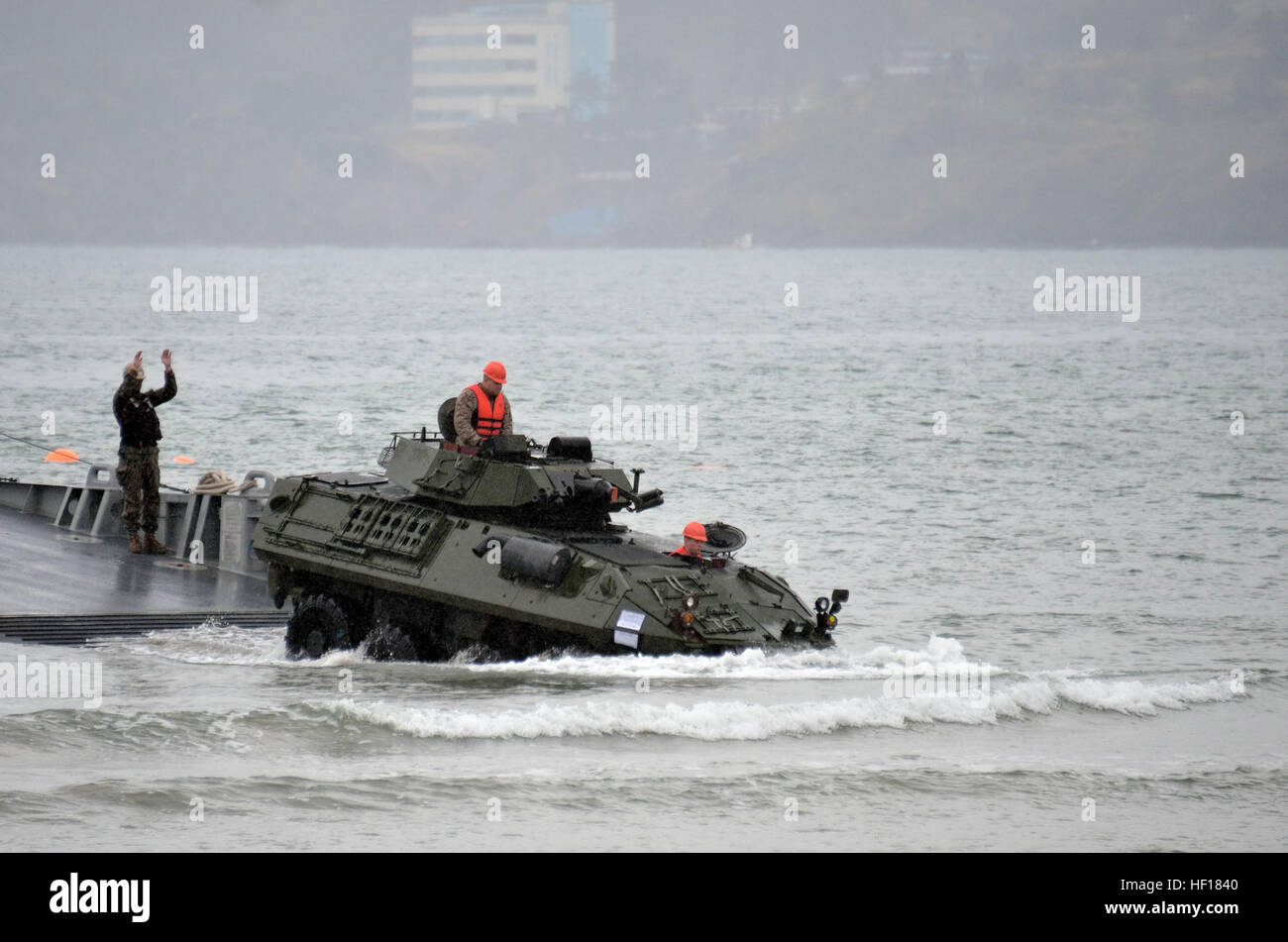 Staff Sgt. Todd J. Piluk, center, and Cpl. Charles H. Parmley, right, drive a light armored vehicle to shore during a maritime prepositioning force off-load April 20 at Dogu Beach near Pohang, Republic of Korea. The Joint Integration and Transportability Branch in Marine Corps Systems Command's Systems Engineering Interoperability Architectures and Technology office works with the Navy to ensure Marines and their systems are able to move smoothly from operations aboard Navy ships directly into operations ashore. (U.S. Marine Corps photo by Cpl. Mark W. Stroud) Marine Corps, Navy teams work to  Stock Photo