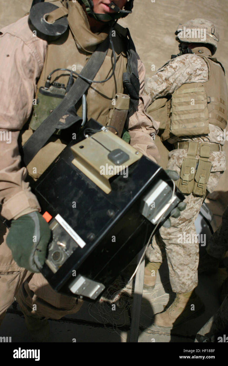 061103-M-7387J-049 Hadithah Al Anbar, Iraq (Nov. 3, 2006) - A recovery team works to secure the black box of an unmanned aerial vehicle, which crash-landed on the roof of a house in the city of Hadithah. U.S. Marines from Fox Company 2nd platoon 3rd squad, along with Quick Reaction Force, hold security while the team works. Fox Company 2nd Battalion, 3rd Marines is deployed with Regimental Combat Team 7, 1st Marine Expeditionary Force (FWD) in support of Operation Iraqi Freedom in the Al Anbar Province of Iraq (MNF-W) to develop the Iraqi Security Forces, facilitate the development of official Stock Photo