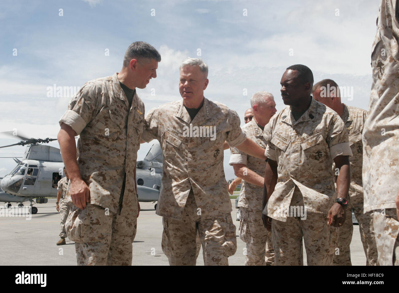 Gen. James F. Amos, 35th commandant of the Marine Corps, is greeted by Lt. Col. Ian Wallace, the commanding officer of Marine Corps Air Station Futenma, and Sgt. Maj. Timothius M. Robinson, sergeant major of MCAS Futenma, after disembarking from a CH-46E Sea Knight during his multi-day visit here, June 14. Amos received briefings from units who took part in Operation Tomodachi. The commandant and Sergeant Major of the Marine Corps Micheal P. Barrett, the 17th sergeant major of the Marine Corps, visited Marine Corps camps on Okinawa and held town hall meetings to discuss current events and futu Stock Photo