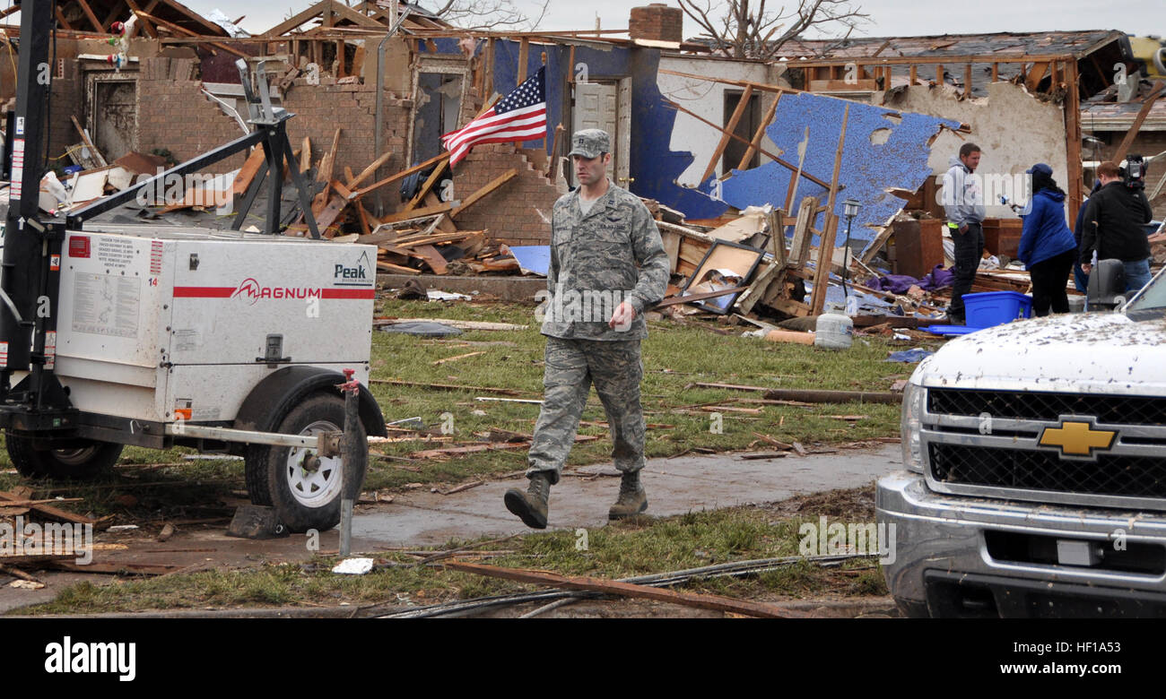 An Air Force member moves through a neighborhood looking for people in need of help in the aftermath of the devastating tornado that ripped through Moore Okla., Monday May 20, 2013.  One of the hundreds of Oklahomans to lose their homes is being interviewed as the Airman watches for downed power lines and debris.  (U.S. Air Force photo by Senior Airman Mark Hybers) Oklahoma recovers after devastating EF-5 tornado (8781363409) Stock Photo