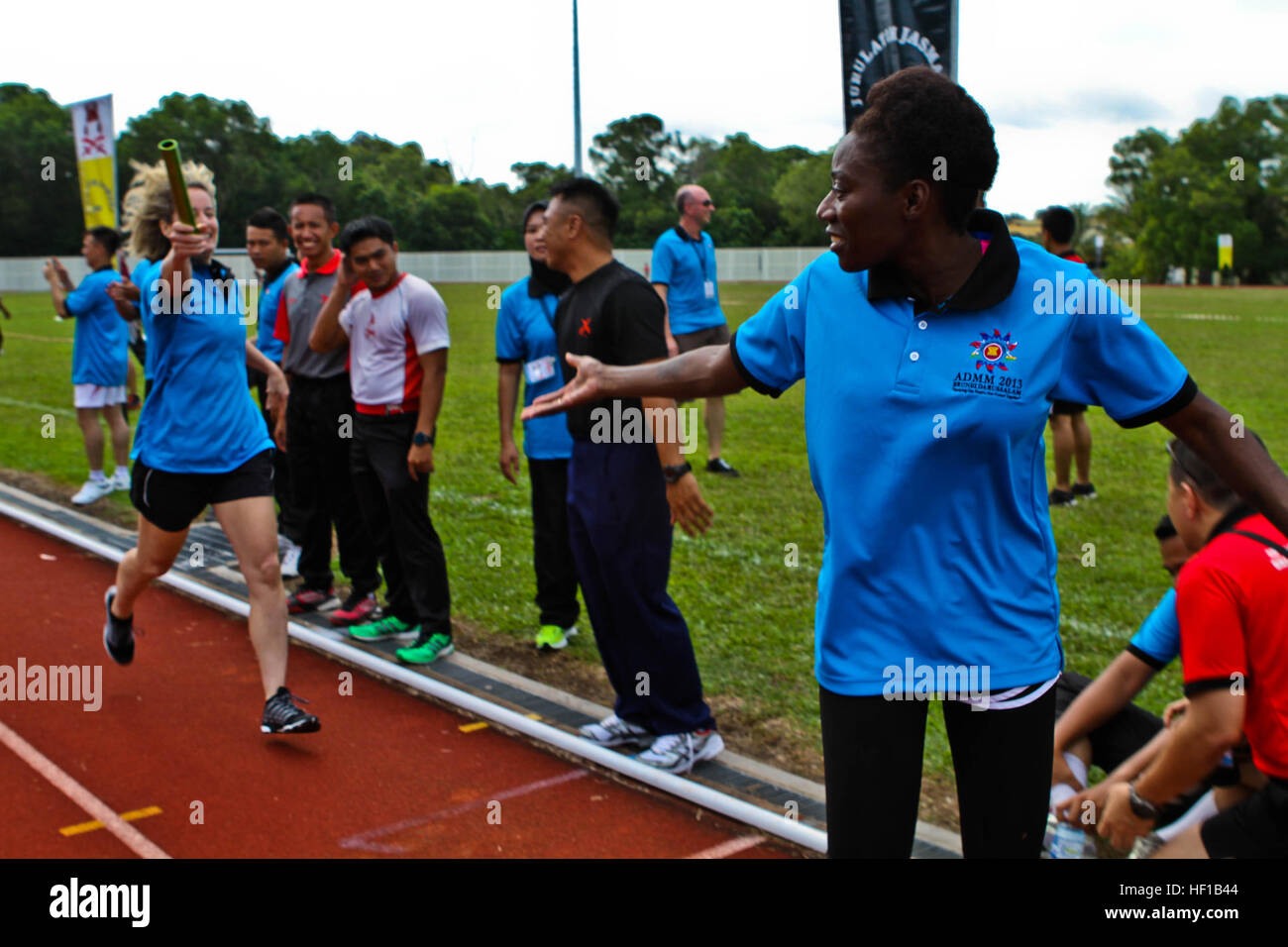 U.S. Army Staff Sgt. Aiyana Harris, right, awaits a baton pass from U.S. Navy Lt. Cmdr. Kristie Robson in a relay race during a sports field meet at Berakas Army Garrison Camp, Brunei Darussalam, June 14. The competition took place as part of the Association of Southeast Asian Nations Defence Ministers Meeting (ADMM) - Plus ASEAN Humanitarian Assistance/Disaster Relief and Military Medicine Exercise (AHMX). During the field meet, nations competed in a four-team, 400-meter relay event and a tug-of-war competition. Harris is a licensed practical nurse at Tripler Army Medical Center. Robson is an Stock Photo