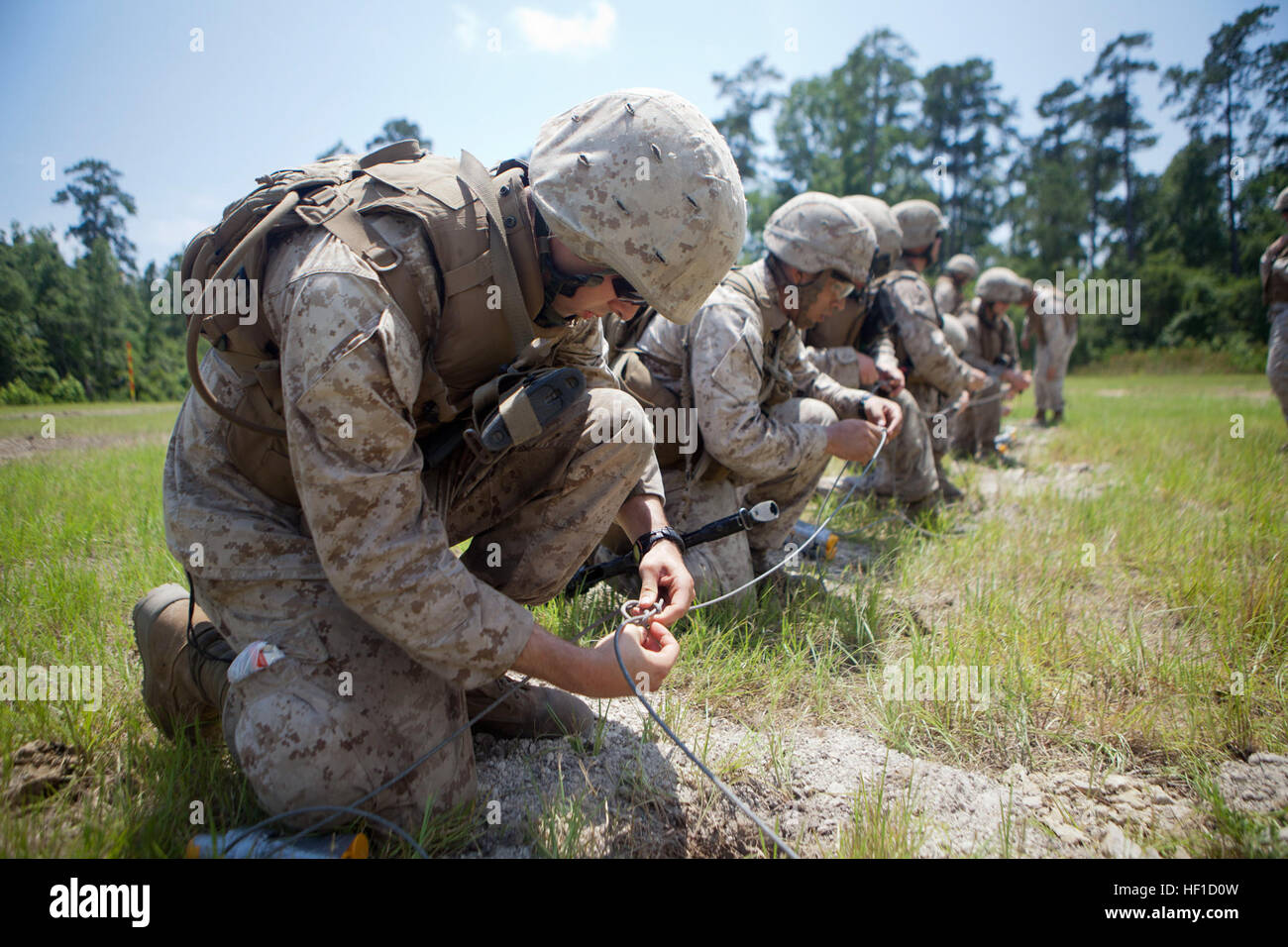 Marines with 2nd and 4th Combat Engineer Battalions and 8th Engineer Support Bn. connect TNT wires using 'the British Junction' knot during a demolition range aboard Marine Corps Base Camp Lejeune, July 23, 2013. The Marines were required to create each type of charge they were going to ignite, to include doughnut, oval, concrete, det-linear, uli-knot slider, fence, window and water charges. (U.S. Marine Corps photo by Cpl. Marcin Platek/Released) 2nd, 4th CEB and 8th ESB Marines complete first Reserve Sapper Course 130323-M-QX735-581 Stock Photo