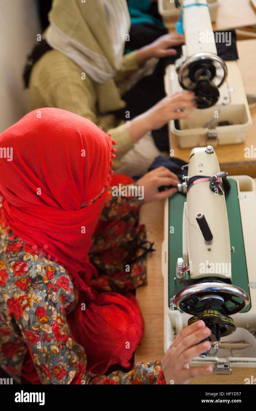 A young Afghan woman practices using a sewing machine to make clothing at the Department of Women's Affairs office in Lashkar Gah, Helmand province, Afghanistan, July 24. She is one of more than 50 women who regularly attend the vocational schools held at the DoWA that aims to teach women employable skills so they may financially support themselves and their families. Educating Afghan Women, DoWA director bests threats, promotes womenE28099s rights in Helmand 130724-M-CT526-764 Stock Photo