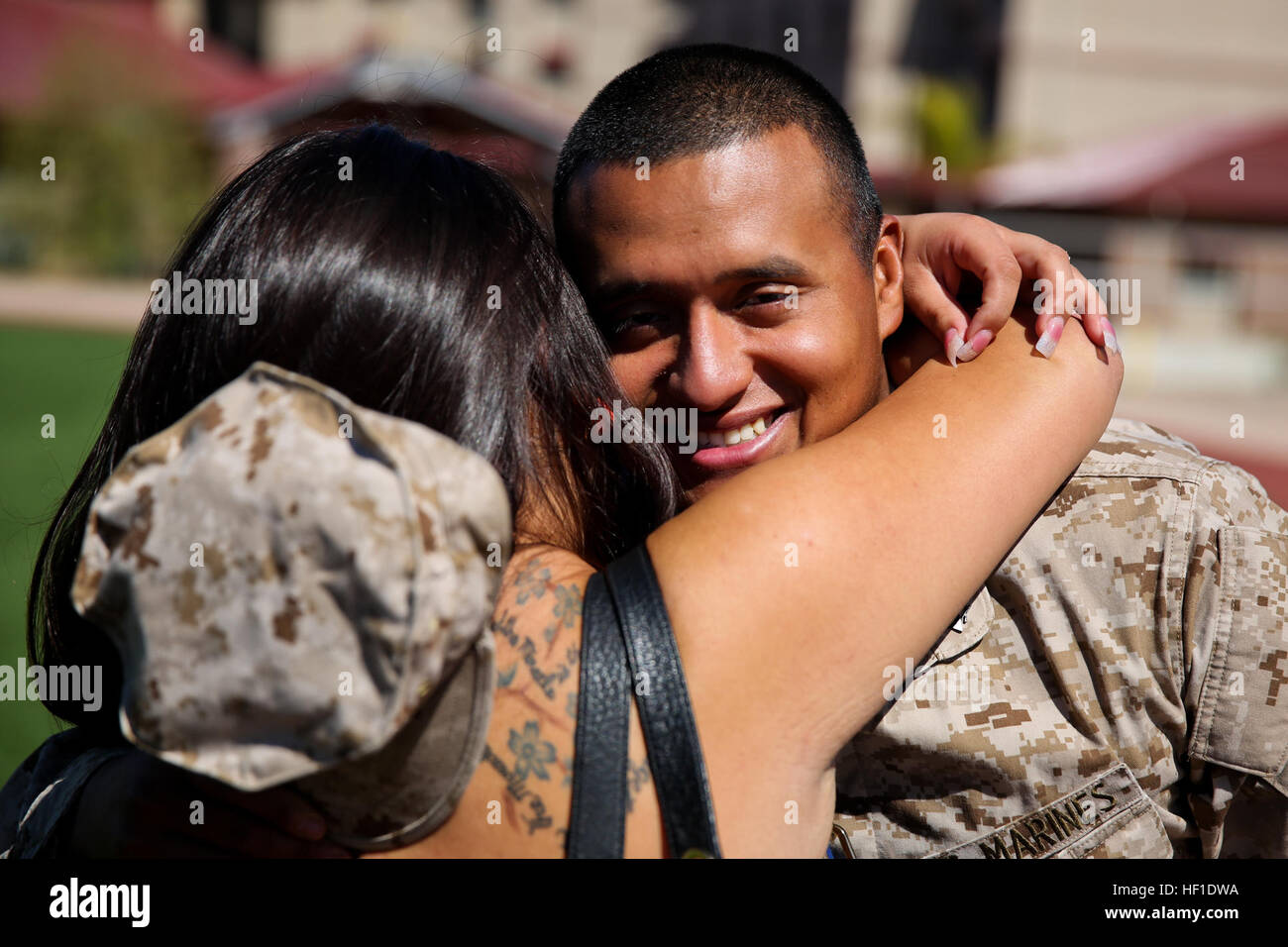 Sergeant Carlos Sanchez, engineer chief, Regimental Combat Team 7, and a native of Little Falls, N.J., embraces his wife Mercedes for the first time in nearly a year aboard Camp Margarita here, Aug. 7. The first main body of RCT-7 personnel returned to family and friends after being deployed approximately 10 months. The servicemembers worked with Afghan forces while deployed to Southwest Afghanistan. RCT-7 waves farewell to Afghanistan, returns home to hugs, kisses 130807-M-PC317-001 Stock Photo