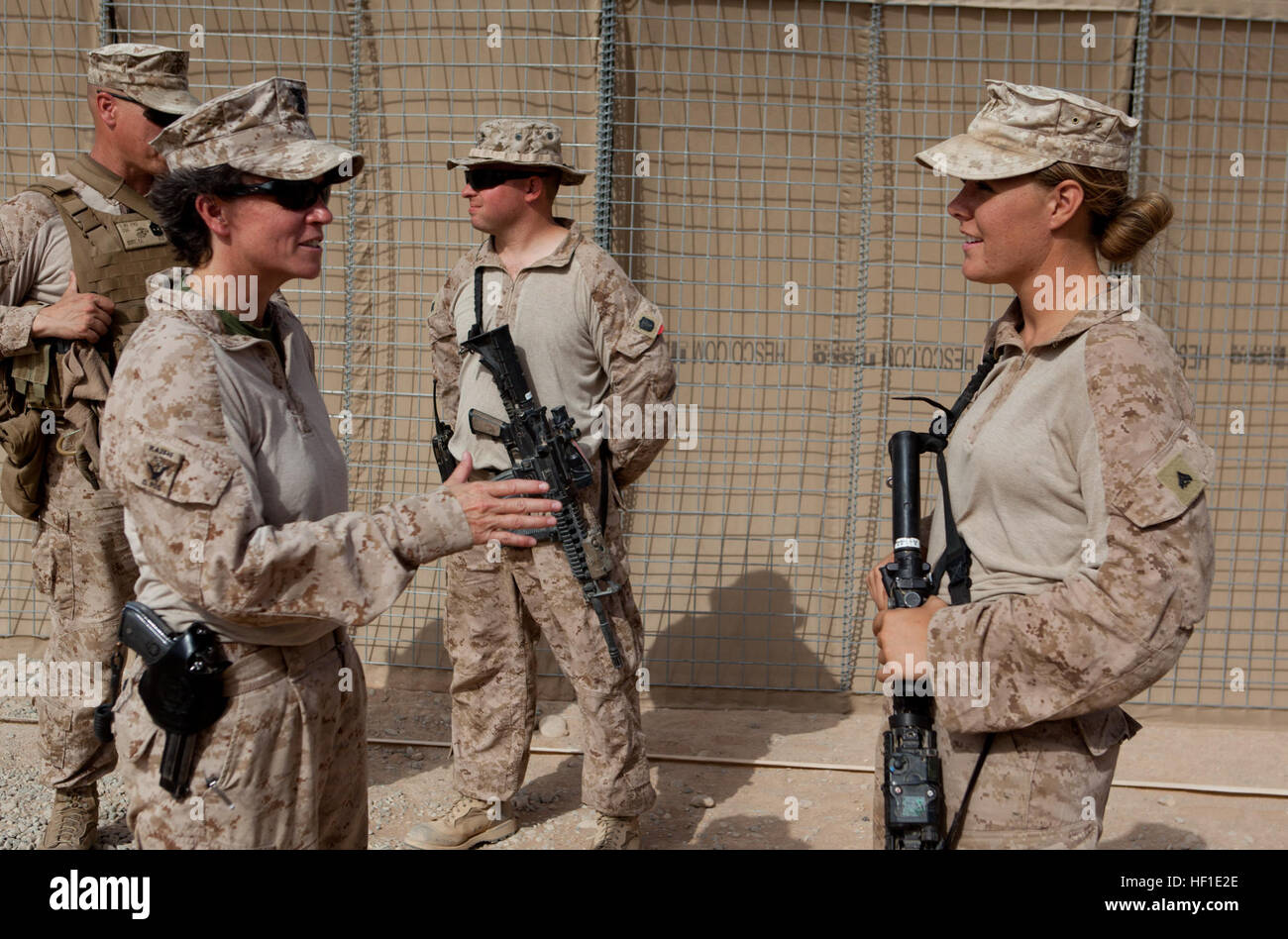 Master Chief Petty Officer Kelly McNulty, command master chief of Regional Command (Southwest), speaks with a Marine from Combat Logistics Regiment 2, RC(SW), at the site of recent infrastructure improvement projects at Camp Dwyer, Afghanistan, Aug. 11, 2013. McNulty visited the troops to maintain an on-the-ground feel for conditions and inspect recent construction projects. Maj. Gen. Miller visits Camp Dwyer troops 130811-M-ZB219-406 Stock Photo