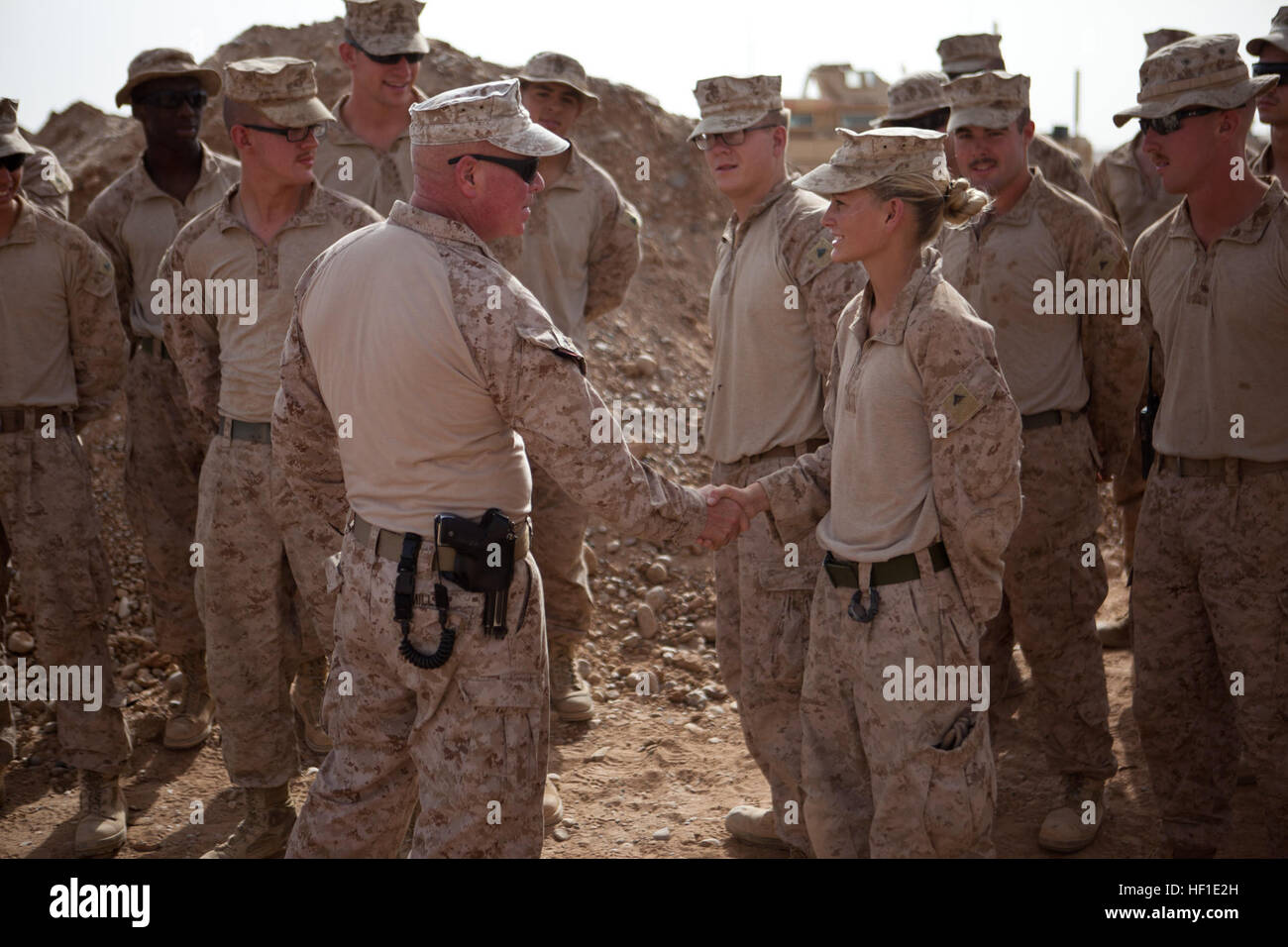 Maj. Gen. Walter Miller (left), commanding general Regional Command (Southwest), shakes hands with Lance Cpl. Caitlin Foresman, a Snow Show, Penn., native and combat engineer with Combat Logistics Regiment 2, RC(SW), during a battlefield circulation at Camp Dwyer, Afghanistan, Aug. 11, 2013. Miller visited the troops to maintain an on-the-ground feel for conditions there and personally speak with base personnel. Maj. Gen. Miller visits Camp Dwyer troops 130811-M-ZB219-608 Stock Photo