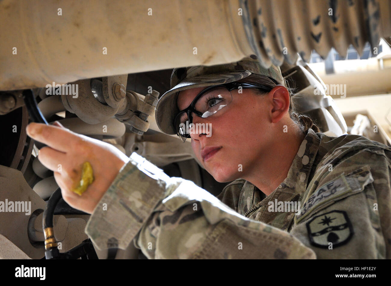 Spc. Michelle Metzger, a motor transport operator with 1487th Transportation Company, Ohio Army National Guard, applies grease to her vehicle at Multinational Base – Tarin Kot, Afghanistan, Aug. 12, 2013. Metzger, a mine resistant ambush protected vehicle driver, performs daily maintenance on the vehicle. (U.S. Army National Guard photo by Sgt. Jessi Ann McCormick) 3,000 miles in Afghanistan 130812-Z-FS372-442 Stock Photo