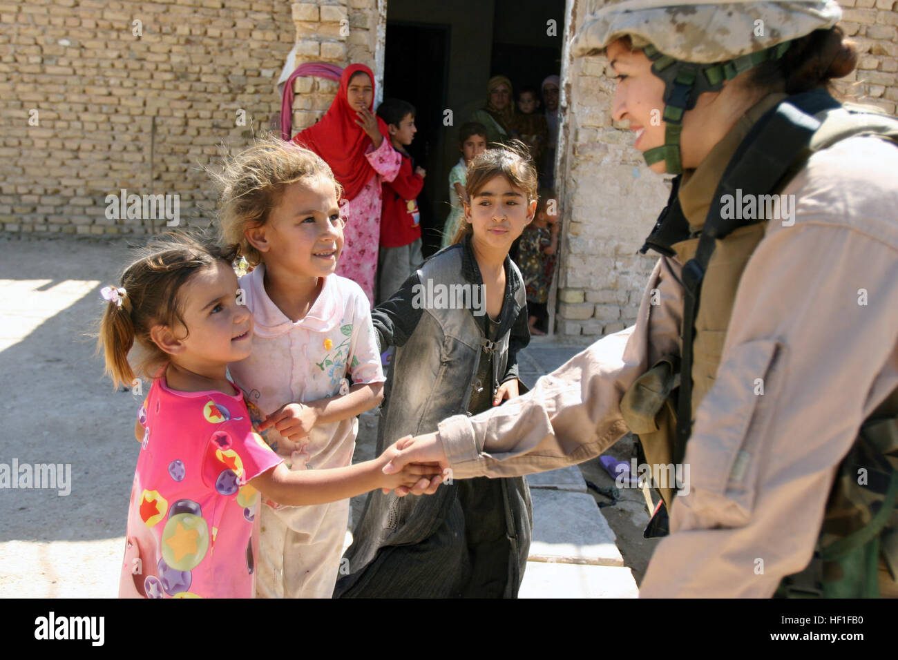 070928-M-0984M-006 KABANI, Iraq (Sept. 28, 2007) - Cpl. Julia Venegas, attached to 2D Marine Logistics Group, shakes hands with a little girl while on a security patrol. 2D Marine Logistics Group is deployed within the Al Anbar province to develop the Iraqi Security Force. U.S. Marine Corps photo by Lance Cpl. Robert S. Morgan (RELEASED) US Navy 070928-M-0984M-006 Cpl. Julia Venegas, attached to 2D Marine Logistics Group, shakes hands with a little girl while on a security patrol Stock Photo
