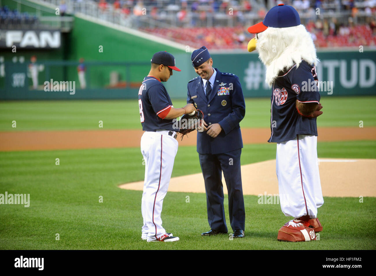 From left to right, Jhonatan Solano, a catcher for the Washington Nationals, U.S. Air Force Lt. Gen. Joseph Lengyel, the vice chief of the National Guard Bureau, and Screech the mascot take a moment during the Washington Nationals 9/11 Remembrance/Heroes Night at the Nationals Park, Washington, D.C., Sept. 13, 2013.  (U.S. Army National Guard photo by Sgt. 1st Class Jim Greenhill/Released) Nationals Sept. 11 Remembrance-Heroes Night 130913-Z-DZ751-220 Stock Photo