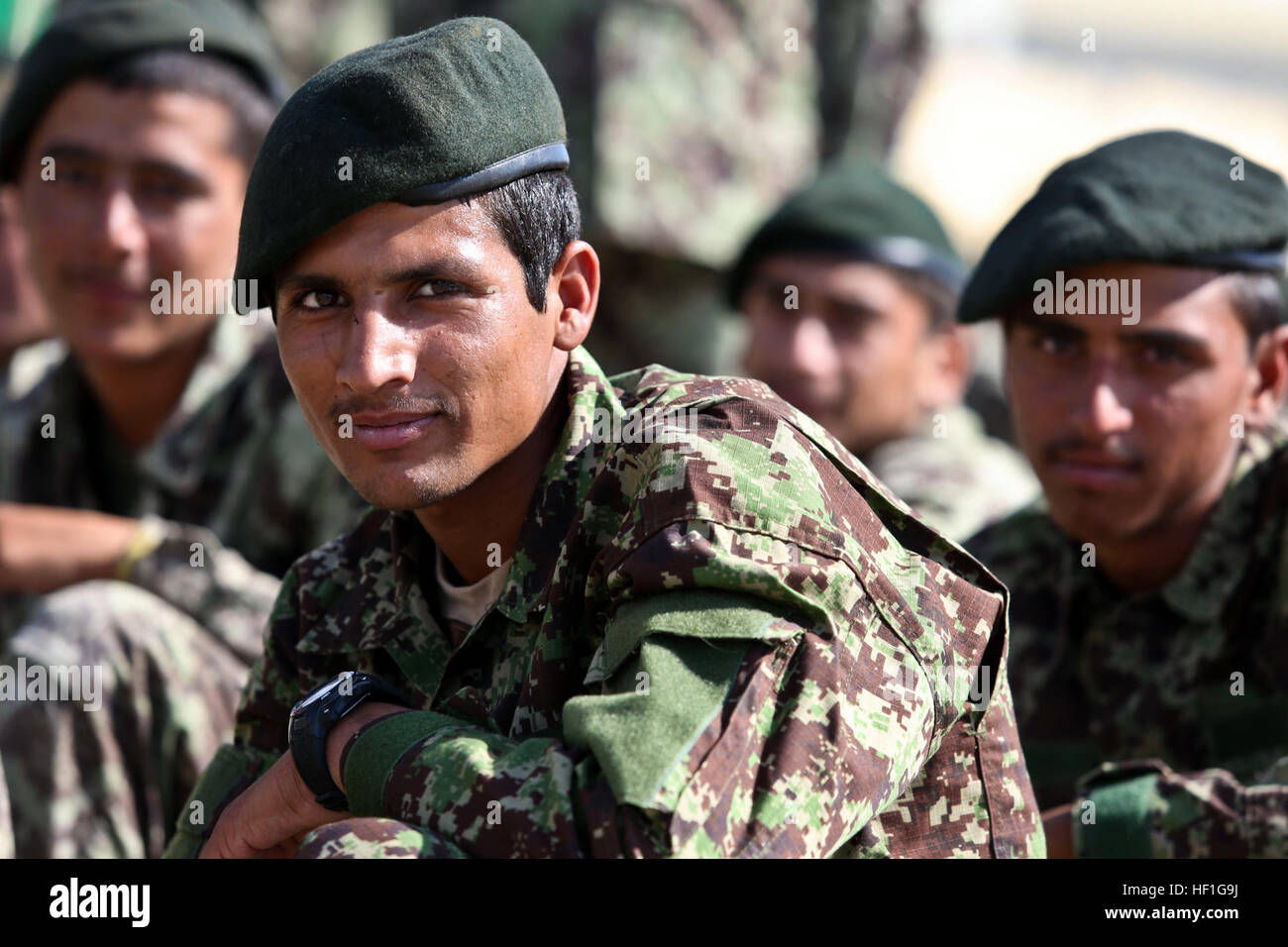 Afghan National Army soldiers with the 215th Corps, sit in formation prior to a ceremony at Camp Shorabak, Helmand province, Afghanistan, Sept. 26, 2013. The soldiers of the 215th Corps celebrated the opening of the Regional Corps Battle School. (U.S. Marine Corps photo by Sgt. Demetrius L. Munnerlyn/Released) Regional Corps Battle School opening 130926-M-ZE445-005 Stock Photo