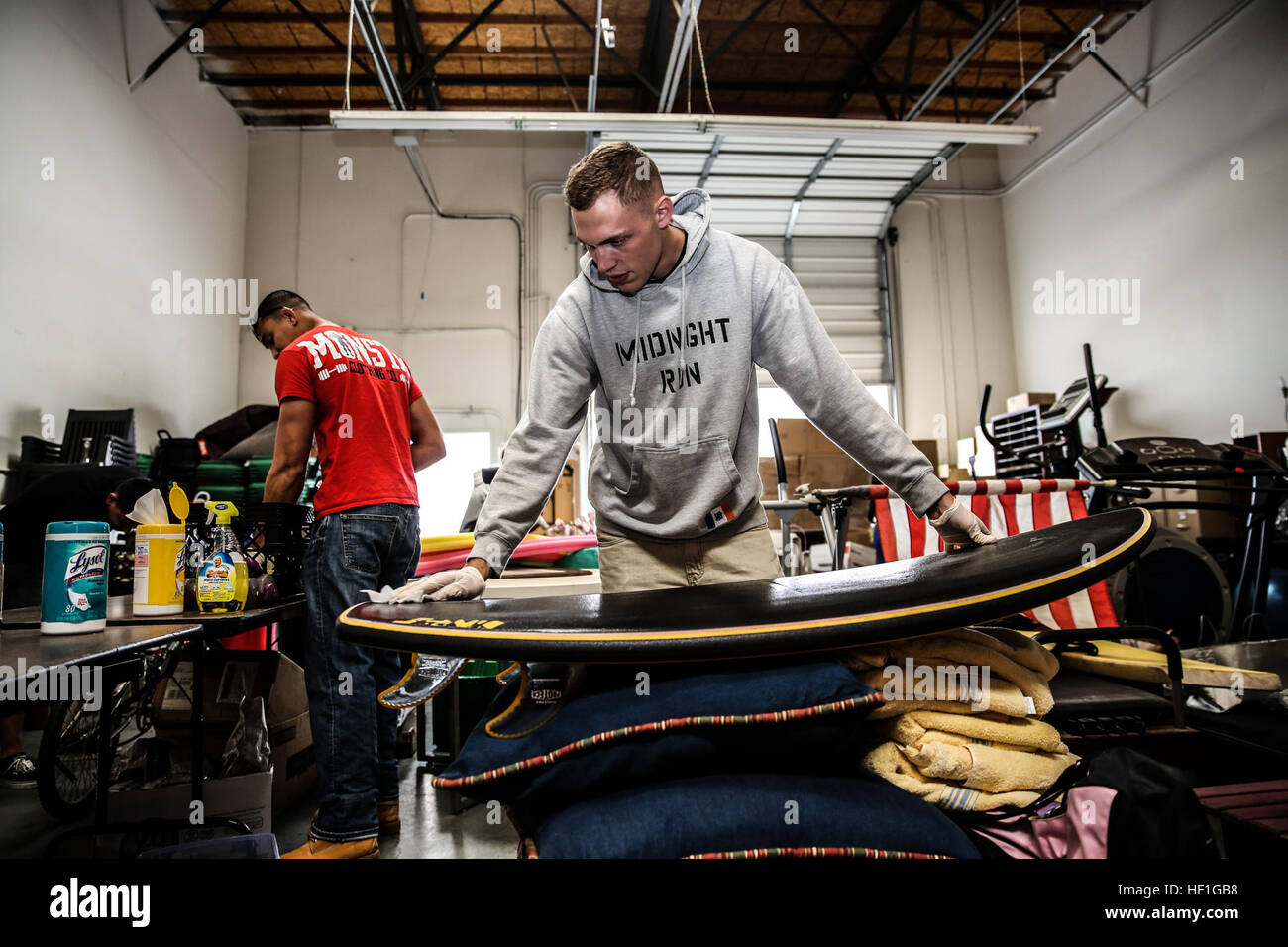 Lance Cpl. Taylor Bukoski, telephone systems and personal computer intermediate repairer, 15th Marine Expeditionary Unit, cleans a surfboard during a volunteer event at The Angel’s Depot in Vista, Calif., Sept. 26. All donations go to improving the quality of life for senior citizens. Bukoski, 21, is from Wanaque, N.J. (U.S. Marine Corps photo by Cpl. Emmanuel Ramos/Released) Volunteers 130926-M-ST621-001 Stock Photo
