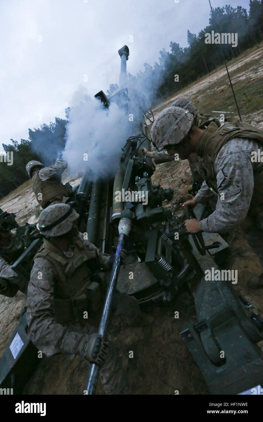 U.S. Marine Corps Pfc. Daniel Nunez, cannoneer position five, India Battery, 3rd Battalion, 10th Marines, places the ramming staff behind a high explosive round to be inserted into an M777 Howitzer during Operation Rolling Thunder aboard Ft. Bragg, N.C., Oct 18, 2013. 10th Marines deployed to Ft. Bragg to conduct artillery combined arms and fire support training and enhance unit cohesion and proficiency. (U.S. Marine Corps photo by Sgt. Andrew D. Young/Released) 10th Marines Participates in Operation Rolling Thunder 131018-M-TI822-167 Stock Photo