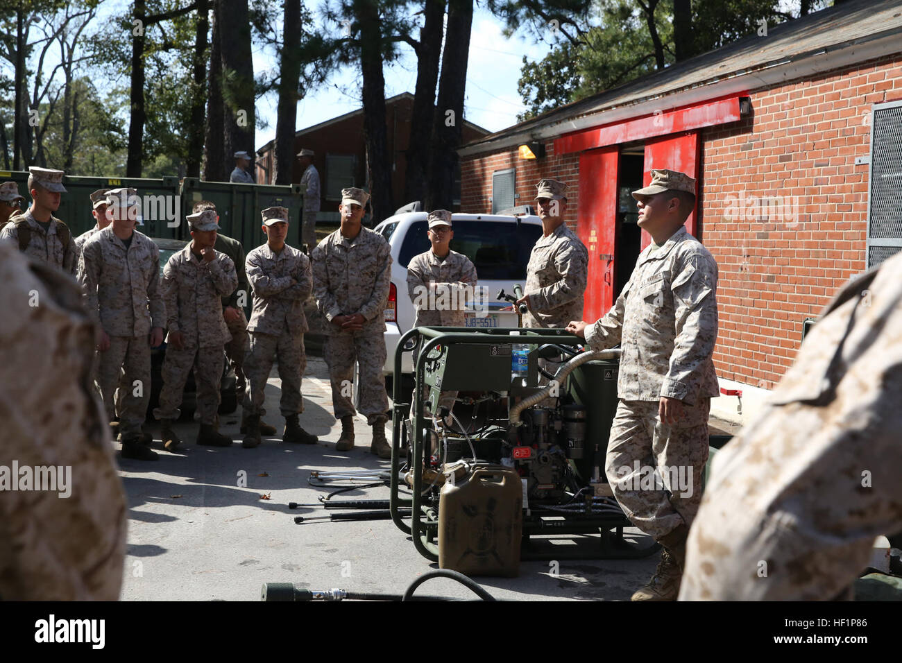 Lance Cpl. Genaro E. Aranda (right), a chemical, biological, radiological and nuclear defense specialist with CBRN Platoon, Combat Logistics Regiment 27, 2nd Marine Logistics Group, speaks to Marines and sailors with 2nd MLG about the M26 Joint Service Transportable Decontamination System during a CBRN decontamination course aboard Camp Lejeune, N.C., Oct. 23, 2013. Students of the week-long course learned about detection of and protection against CBRN agents and the processes of decontaminating troops, equipment and vehicles. License to clean, Marines, sailors qualify for CBRN decontamination Stock Photo