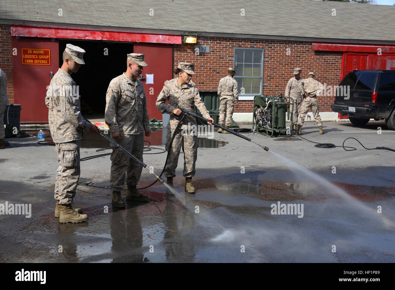 Pfc. Taren C. Seidel (left) a water support technician with 8th Engineer Support Battalion, 2nd Marine Logistics Group, and Lance Cpl. Michelle E. Rusz (right), an administration specialist with Combat Logistics Regiment 27, 2nd MLG, demonstrate the spray capabilities of the M26 Joint Service Transportable Decontamination System during a chemical, biological, radiological and nuclear decontamination course aboard Camp Lejeune, N.C., Oct. 23, 2013. The M26 was designed to be lightweight and have the ability to decontaminate personnel, equipment and vehicles from CBRN agents. License to clean, M Stock Photo
