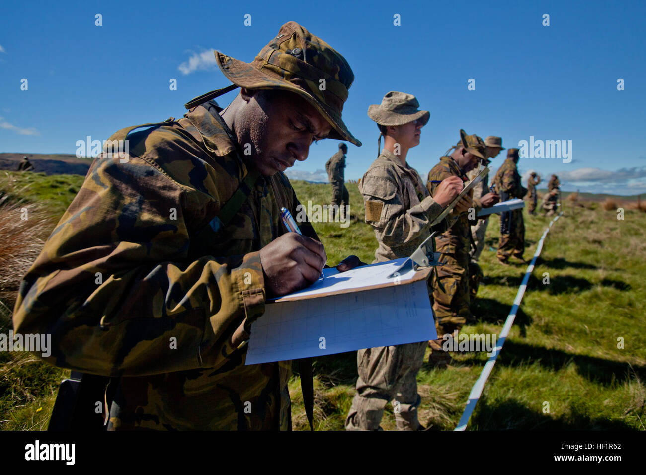 Papua New Guinean engineers from Engineer Battalion and sappers with 2 Field Squadron Royal Engineers based out of Linton Military Camp, New Zealand, identify improvised explosive devices at combat hunter training during the initial stages of exercise Southern Katipo 2013 aboard Waiouru Military Camp, New Zealand, Nov. 9. SK13 is designed to improve participating forces' combat training, readiness and interoperability as part of a Joint Inter-Agency Task Force. Three different uniforms train to identify IEDs during SK13 131109-M-SE196-005 Stock Photo