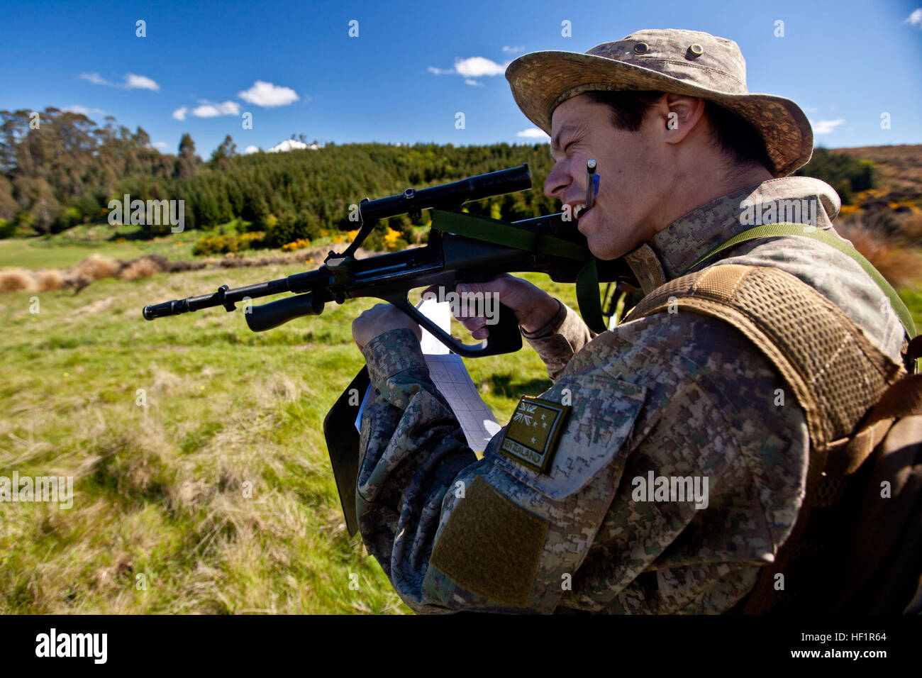 Pvt. Jonathan Sorensen, sapper with 2 Field Squadron Royal Engineers, from Christchurch, New Zealand, looks through his optic to identify hidden improvised explosive devices at combat hunter training during the initial stages of exercise Southern Katipo 2013 aboard Waiouru Military Camp, New Zealand, Nov. 9. SK13 allows service members to collaborate with partner countries to achieve mutual security goals, address shared concerns and continue to enhance our interoperability. Three different uniforms train to identify IEDs during SK13 131109-M-SE196-002 Stock Photo