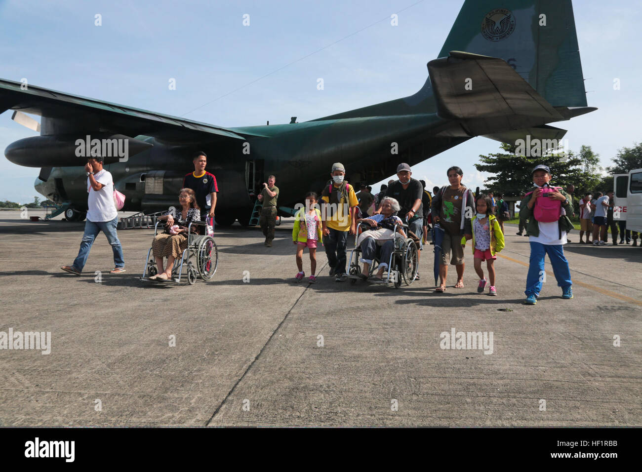 Displaced residents exit a Philippine Air Force KC130J Super Hercules