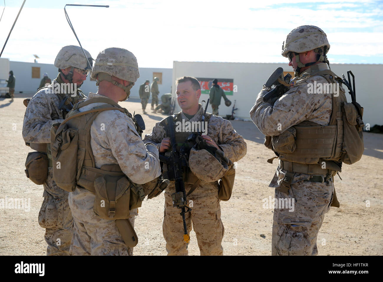 Lieutenant Col. Seth E. Yost, commanding officer, 1st Battalion, 7th Marine Regiment, speaks with company commanders during a counterinsurgency exercise on Range 220 at Marine Corps Air Ground Combat Center Twentynine Palms, Calif., Dec. 9, 2013. The $140 million urban warfare training facility consists of more than 1,000 buildings and is divided into four sectors. The buildings replicate what can be found in an urban town to include gas stations, factories, one story complexes, marketplaces and multiple story buildings. The battalion is slated to continue a vigorous training schedule before d Stock Photo