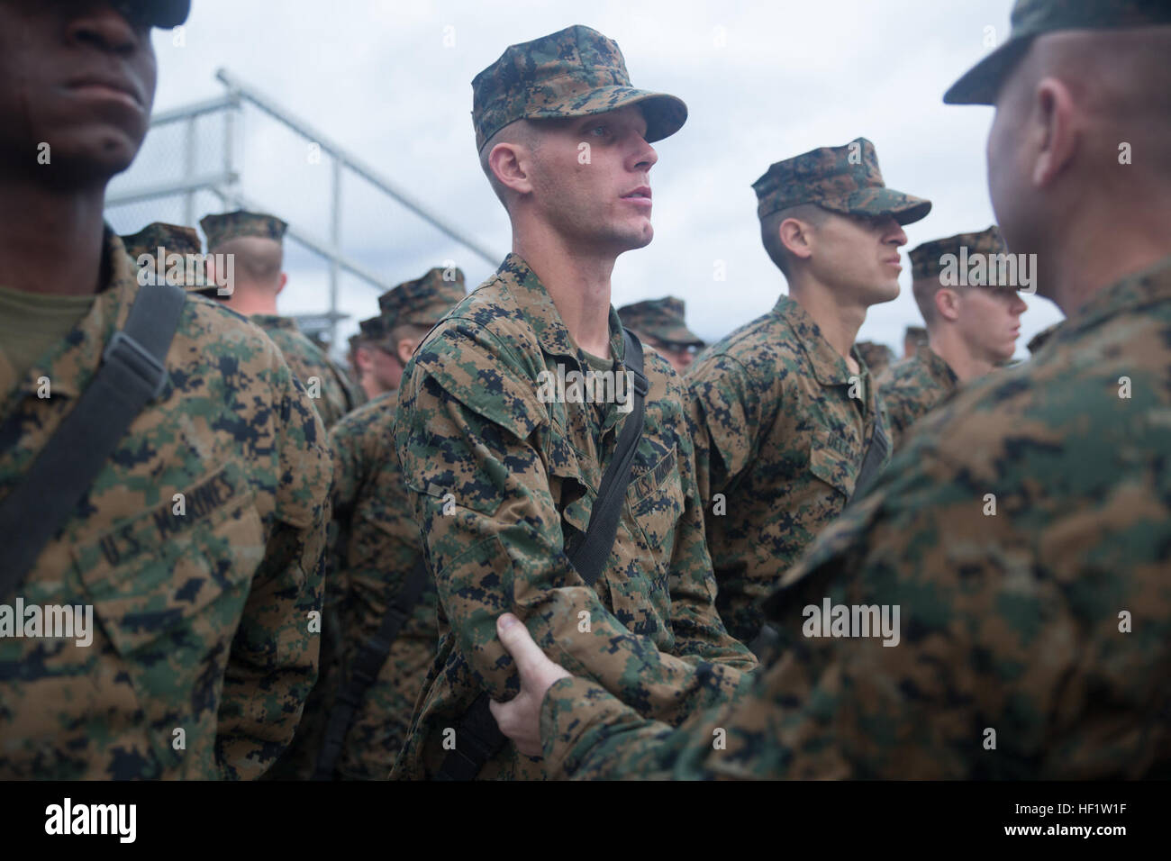Sgt. Maj. Jerry Bates II presents his son, Rct. Jerry Bates III, with his  Eagle, Globe and Anchor emblem during a ceremony Dec. 14, 2013, on Parris  Island, S.C. Bates reported to