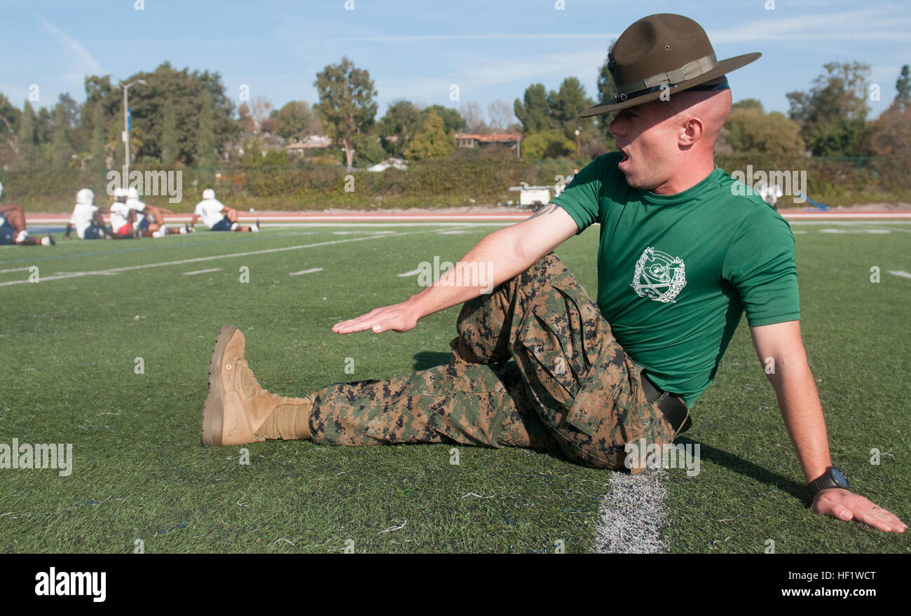 Gunnery Sgt. Michael Wampler, a drill instructor stationed at Marine Corps Recruit Depot San Diego, does warm-up exercises at the Semper Fidelis All-American Bowl practice at Fullerton College Jan. 4 2014. The bowl game will take place at the StubHub Center and will be aired live on Fox Sports 1 Network Jan. 5 2014, 6- 8 p.m. PST/9:30- 11:00 p.m. EST. The bowl brings selected players together with U.S. Marines and football coaches to develop skills not only important to football, but throughout life, such as leadership, self-confidence and teamwork. (Marine Corps photo by Lance Cpl. Stanley Ca Stock Photo