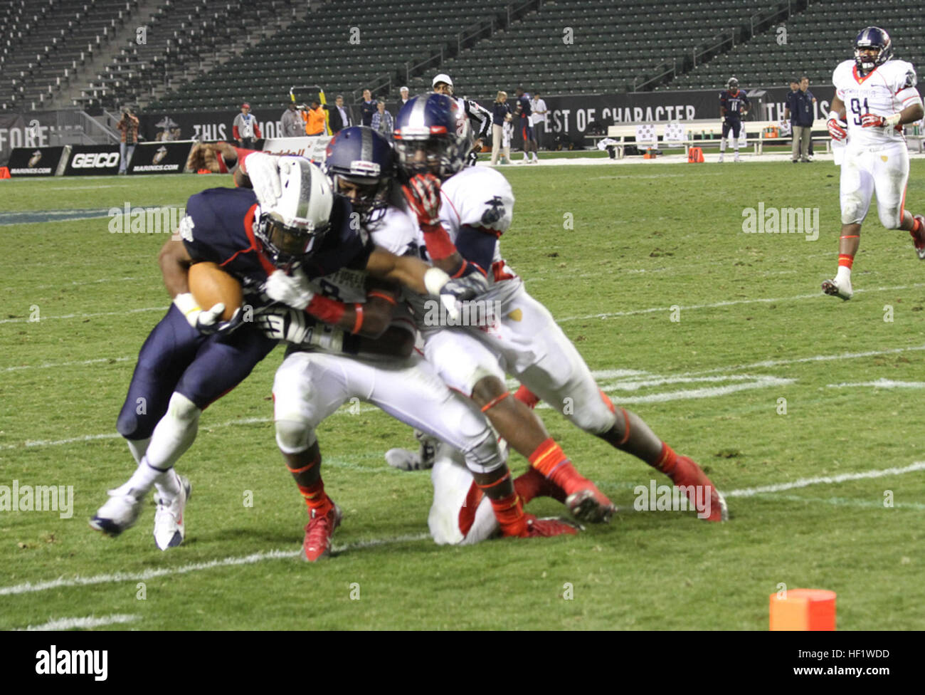 CARSON, Calif. - Adarius Pickett, a cornerback with the Semper Fidelis All-American Bowl West Team and an El Cerrito, Calif., native, and Deondre Clark, a defensive end with the West Team and Oklahoma City, Okla., native, tackle Madre London, a running back with the Semper Fidelis All-American East Team and Fort Lauderdale, Fla., native, during the Semper Fidelis All-American Bowl at The StubHub Center in Carson, Calif., Jan. 5, 2014. The West Team defeated the East 31 to 24 as part of the Semper Fidelis Football Program which brought together over 90 of the best high-school football players i Stock Photo