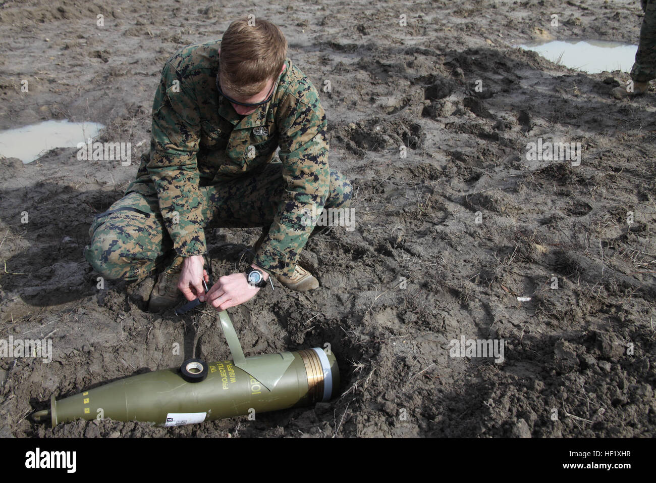 Sgt. David J. Schulz attaches detonating cord to sheet explosives as he