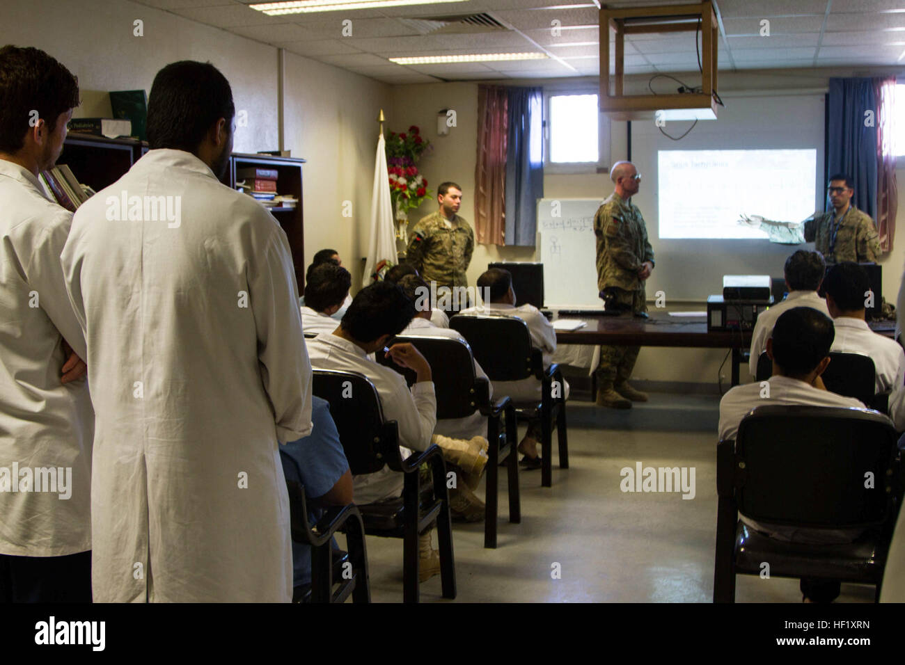 Medical staff of the Kandahar Regional Military Hospital attend a class on electrocardiography taught by two members of the North Atlantic Treaty Organization Role 3 Multinational Medical Unit at Camp Hero, Afghanistan, Feb. 11, 2014.  The first portion of the class was taught by Cmdr. Sean Bryant, as a part of an ongoing educational partnership between KRMH and the MMU. (U.S. Army photo by Cpl. Mariah Best) EKG training brings confidence to KRMH staff 140211-Z-TF878-549 Stock Photo