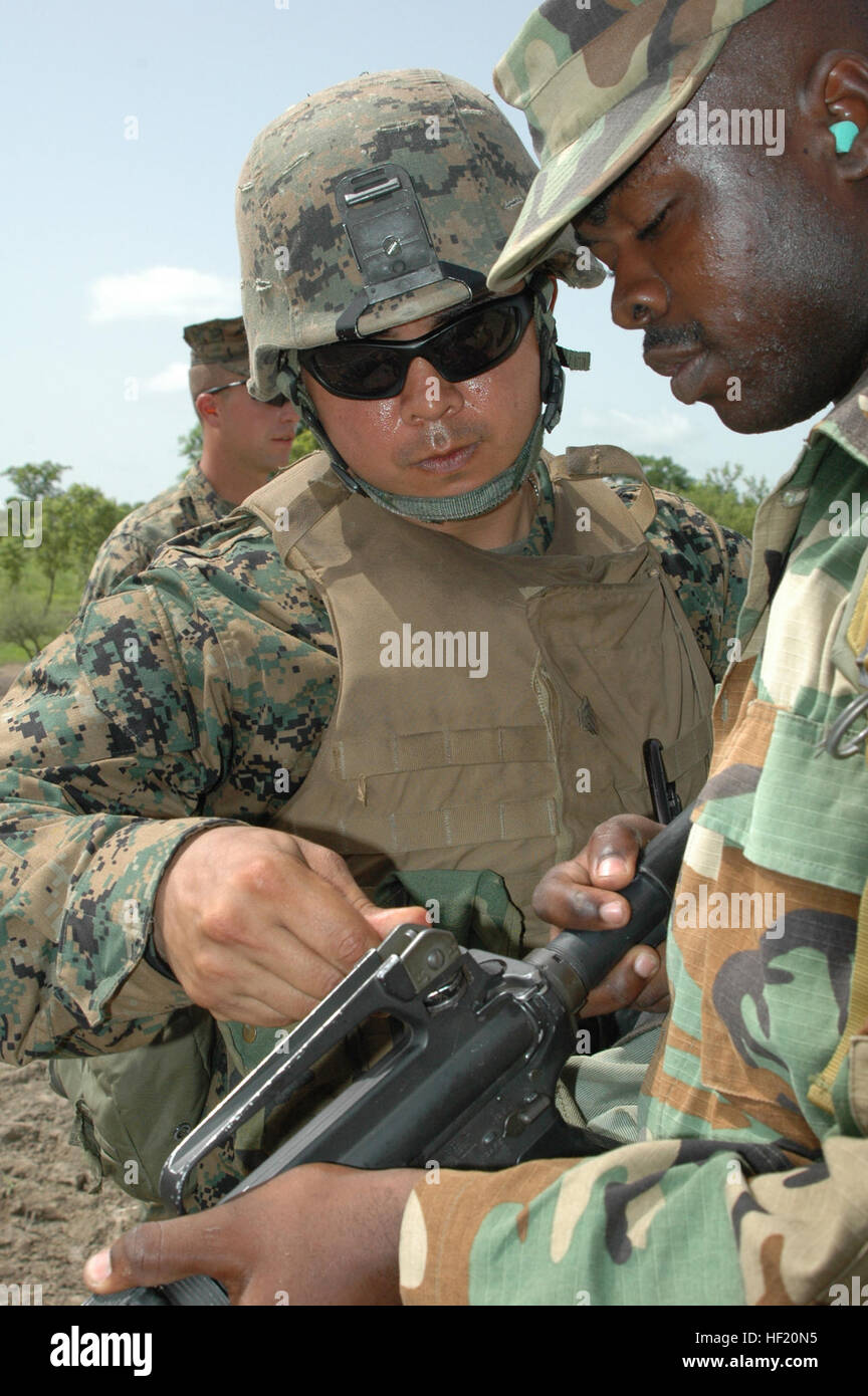 Sgt. Israel Maldonado, Company C, 1st Battalion, 23rd Marine Regiment, shows a Ghanaian infantry soldier how to adjust his rifle sightings during exercise Shared Accord 2008 here June 16. Maldonado, a reservist and Weslaco, Texas resident, was one of almost 300 Marines participating in the exercise that focused not only on infantry training, but supported various humanitarian assistance projects benefiting thousands of Ghanaians and their animals June 10 -26. USMC-080616-M-3892P-001 Stock Photo
