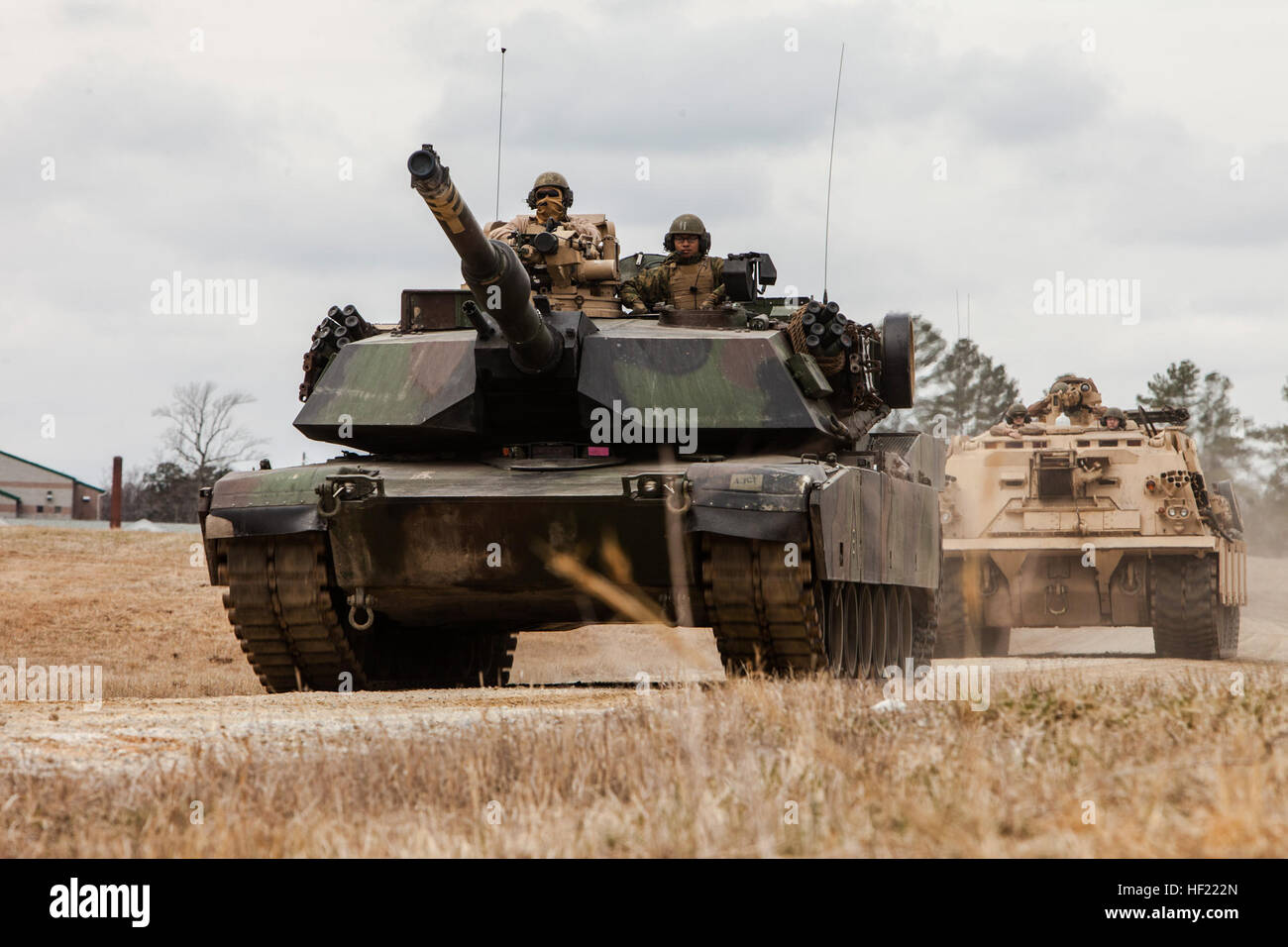 U.S. Marine Corps Cpl. Matthew Moores, left, a tank commander, and Lance Cpl. Luis Rosas, loader, 2nd Tank Battalion, 2nd Marine Division, head to the tank ramp on an M1A1 Abrams tank followed by an M88 A2 Hercules Recovery Vehicle, during a Deployment for Training (DFT) Exercise at Fort Pickett, Va., March 28, 2014. The DFT is conducted to strengthen the unit's proficiency in a combat environment.  (U.S. Marine Corps photo by Lance Cpl. Kelly Timney, 2nd MarDiv, Combat Camera/Released) 2nd Tank Battalion Deployment for Training Exercise (DFT) 140328-M-OU200-323 Stock Photo