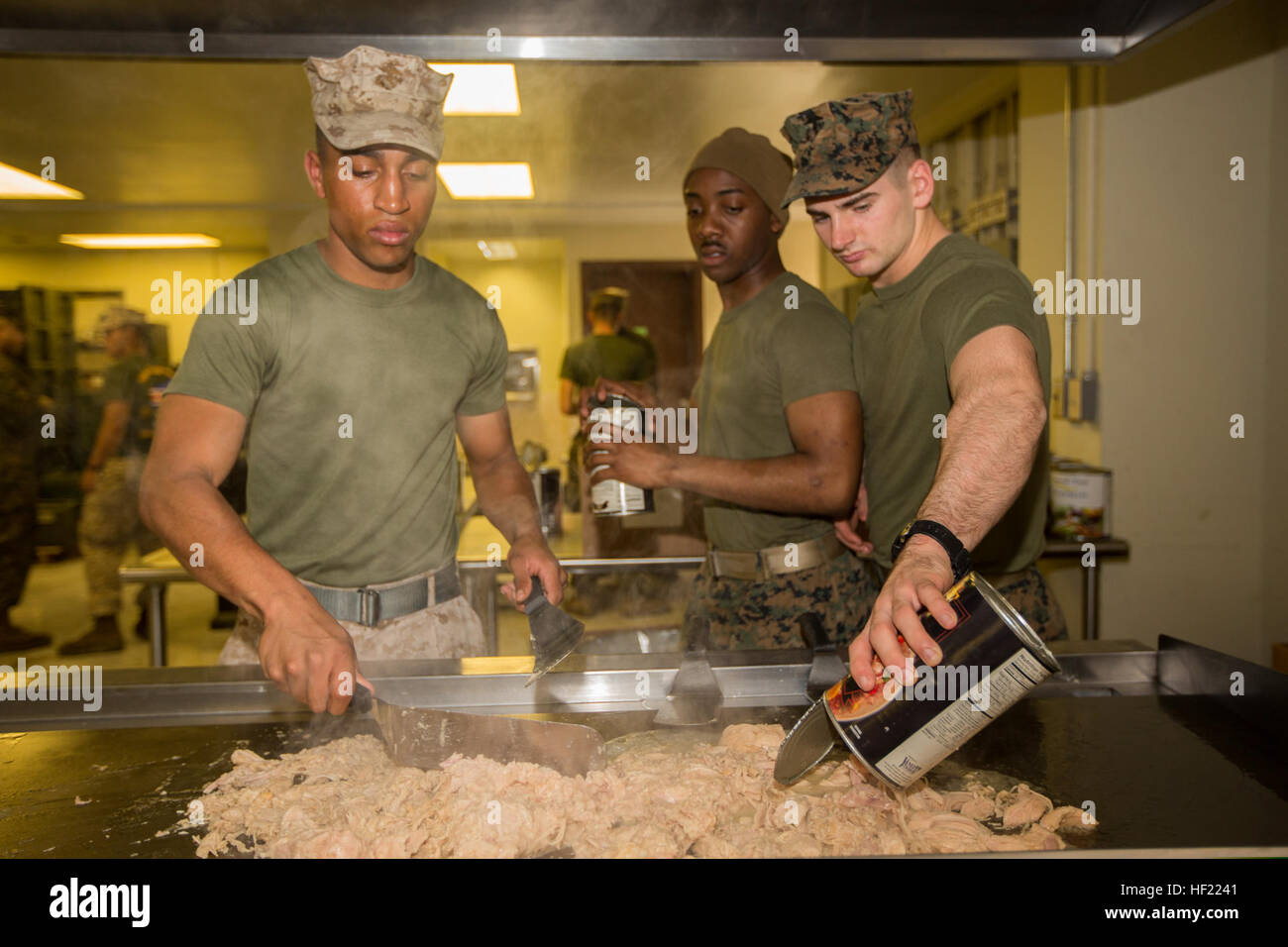 U.S. Marines prepare chicken on a grill in the dining facility at Camp Mujuk, South Korea, March 28, 2014, during exercise Ssang Yong 2014. Ssang Yong is a combined U.S.-South Korean combat readiness and joint/combined interoperability exercise designed to advance South Korean command and control capabilities through amphibious operations. (U.S. Marine Corps photo by Lance Cpl. Tyler S. Dietrich/Released) U.S. Marines prepare chicken on a grill in the dining facility at Camp Mujuk, South Korea, March 28, 2014, during exercise Ssang Yong 2014 140328-M-UQ794-064 Stock Photo