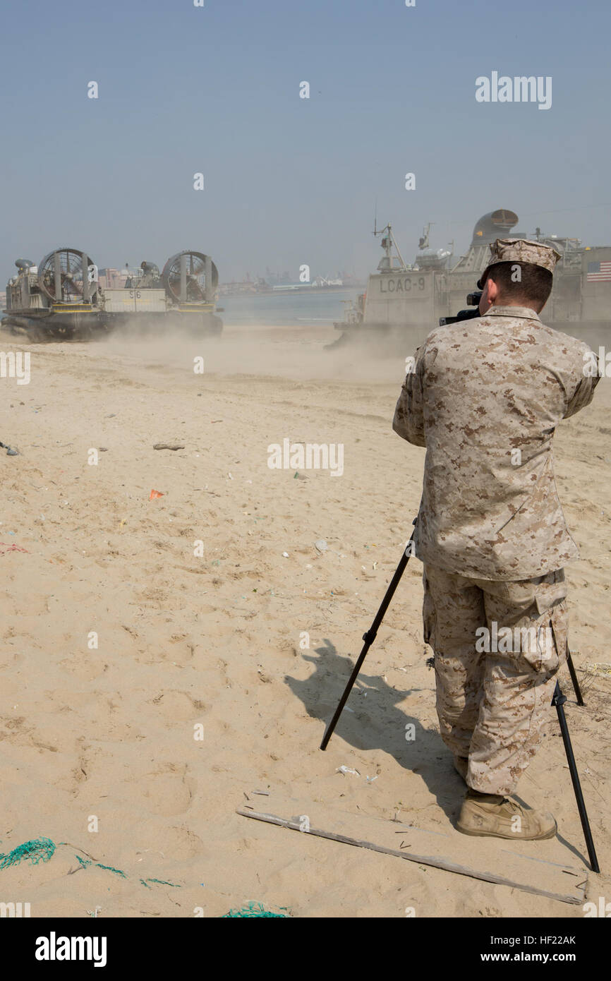 U.S. Marine Corps Lance Cpl. Jacob Hug, combat videographer, with Marine Corps Installations Pacific Consolidated Combat Camera, records a Landing Craft Air Cushion on White Beach, during Exercise Ssang Yong 14 at Dogue Beach Pohang, South Korea, April 2, 2014. Exercise Ssang Yong 14 is conducted annually in the Republic of Korea (ROK) to enhance interoperability between U.S. and ROK forces by performing a full spectrum of amphibious operations while showcasing sea-based power projection in the Pacific. (U.S. Marine Corps Photo by Lance Cpl. Tyler S. Dietrich/ Released) Dogue Beach, Ssang Yong Stock Photo