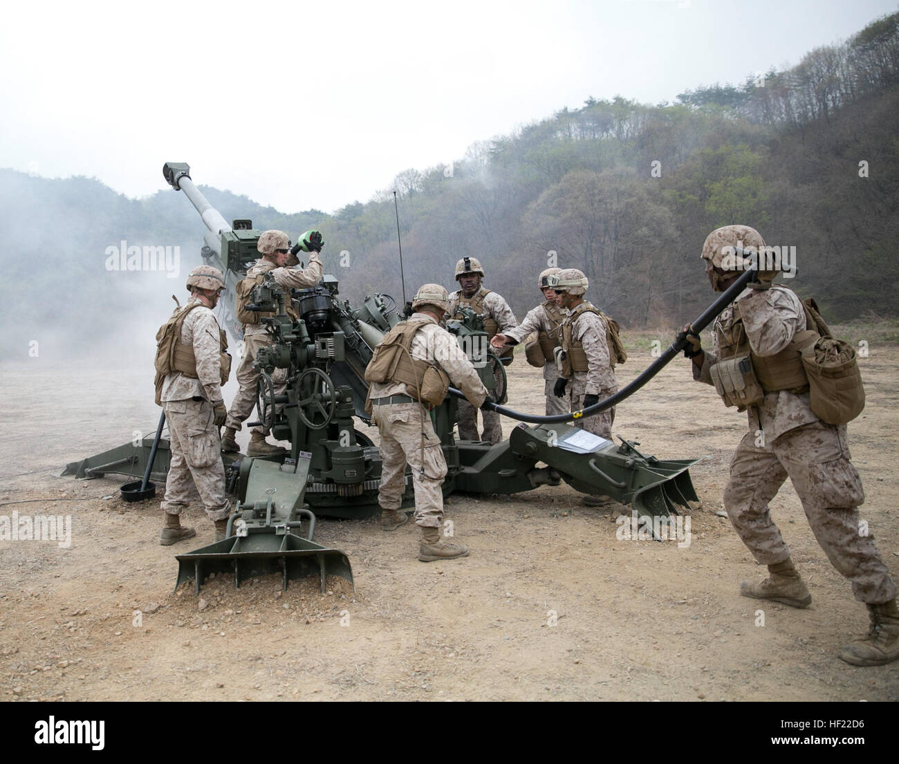 Lance Cpl. Aaron Manigault holds the rammer to push a round into an M777A2 lightweight 155 mm howitzers April 3 at Su Seung-ri Range in the Republic of Korea as part of Exercise Ssang Yong 2014. The Marines shot off eight rounds during the calibration portion of the live-fire, followed by another 40 rounds in succession. Ssang Yong is an exercise that showcases the amphibious and expeditionary capabilities of the ROK and U.S. forces as well as the maturity of the relationship between the two nations. Manigault, a native of New York City, is a field artillery cannoneer with Golf Battery, 2nd Ba Stock Photo