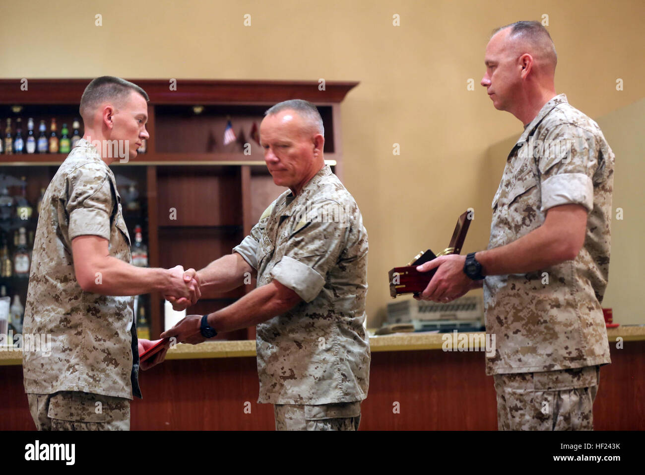 Major Gen. Lawrence D. Nicholson, center, the commanding general of 1st Marine Division, awards Cpl. Jager Hibler, left, a motor transportation operator with 3rd Combat Engineer Battalion, the 2013 Marine Corps Motor Transport Association’s Operator of the Year award during an award ceremony aboard Marine Corps Base Camp Pendleton, Calif., April 30, 2014. Hibler, a 22-year-old native of Alamogordo, N.M., has traveled 1,500 miles throughout combat zones in Helmand province, Afghanistan, where he transported personnel and key equipment across his area of operations. 1st MarDiv motor transportati Stock Photo