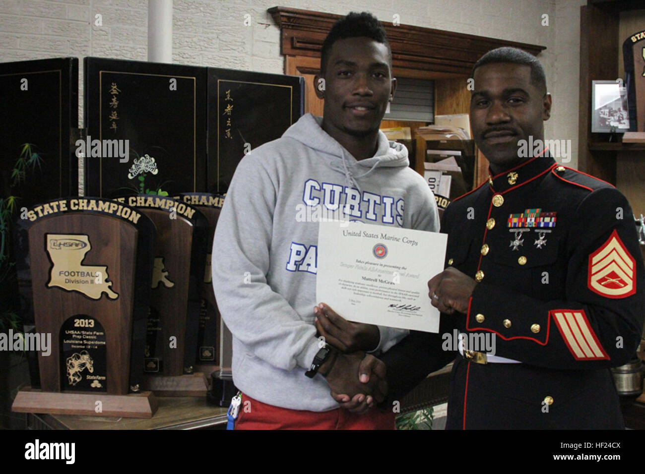 Tito Windham, a football player from John Curtis Christian High School, is presented a Semper Fidelis All-American Bowl certificate by Staff Sgt. Melvin Jackson, a Marine Corps recruiter, for his participation, May 6. Participants in the SFAAB are selected for being the top rated high school football players in the nation. The Marine Corps also looks at the player's character, academic performance and proven leadership skills during the selection tour. SFAAB Presentation 140506-M-YE163-001 Stock Photo