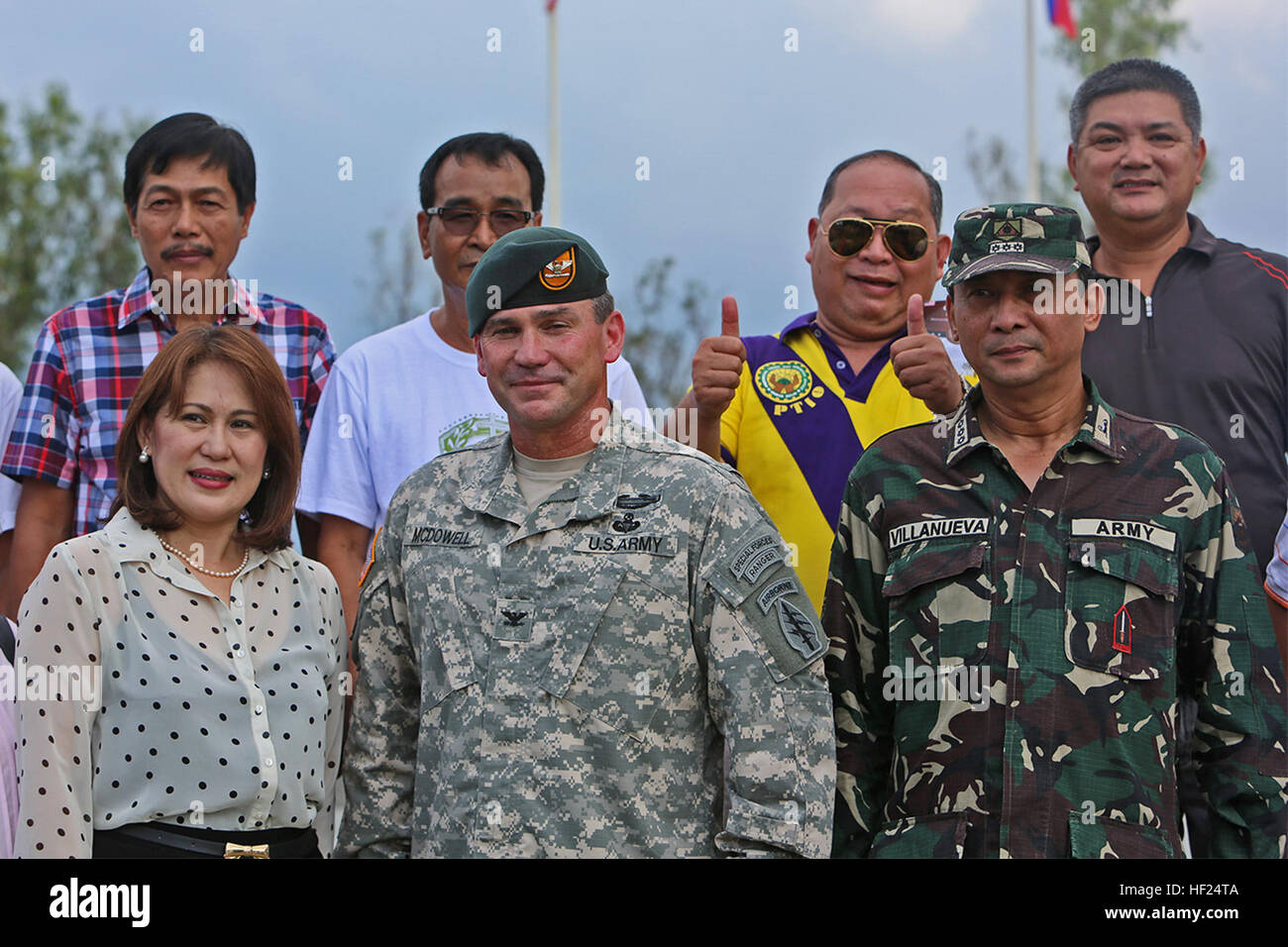 Philippine Army Col. Ronald Villanueva, right, chief-of-staff of 7th Infantry Division, and U.S. Army Col. Robert McDowell, center, commanding officer of Joint Special Operations Task Force - Philippines, meet Carolina Dg Uy, left, provincial tourism officer of Nueva Ecija, after a wreath-laying ceremony May 10 at the Pangatian War Memorial in Cabanatuan, N.E., Philippines, during exercise Balikatan 2014. The ceremony honored Philippine and U.S. soldiers interred at the Cabanatuan Prison Camp, some of whom were liberated by Philippine guerrillas and the U.S. Army's 6th Ranger Battalion during  Stock Photo