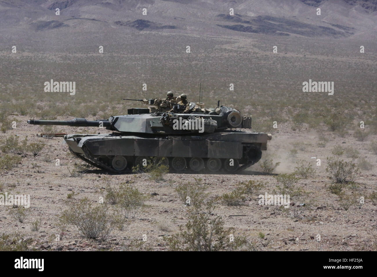 Marines with Alpha Company, 1st Tank Battalion, advance on a mock enemy position in an M1A1 Abrams during Exercise Desert Scimitar 2014 aboard Marine Corps Air Ground Combat Center Twentynine Palms, Calif., May 11, 2014. A tank's success on the battlefield is defined by the teamwork of its four crewmen, who each play a vital role. The mission cannot be completed without every member. Each crewman has a specific yet equally important job required to operate the vehicle. (U.S. Marine Corps photo by Cpl. Christopher J. Moore/Released) 1st Tank Bn. blasts through Exercise Desert Scimitar 2014 1405 Stock Photo