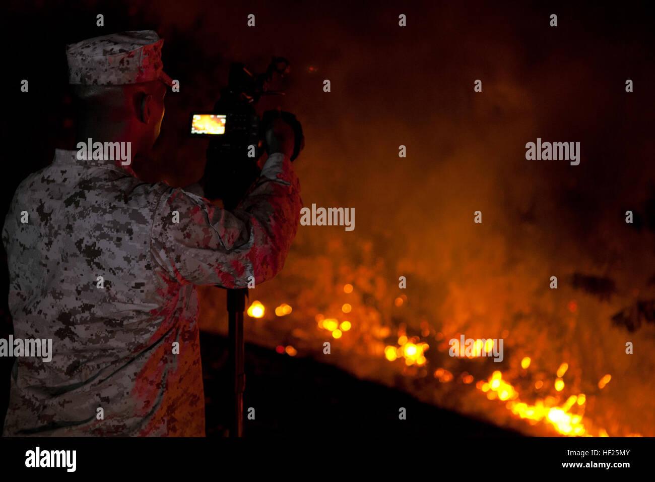 U.S. Marine Sgt William Lewis, a Combat Camera Videographer with Headquarters and Support Battalion, Marine Corps Installations West-Marine Corps Base Camp Pendleton, records the Las Pulgas Fire as it burns near the 32 Area at Camp Pendleton, Calif., 15 May, 2014. The Las Pulgas Wildfire on Camp Pendleton has burned more than 15,000 acres and is the largest fire in San Diego County history. (U.S. Marine Corps photo by Sgt. Ethan Johnson/MCIW-MCB CamPen COMCAM/Released) Camp Pendleton Fires 140515-M-HU778-022 Stock Photo