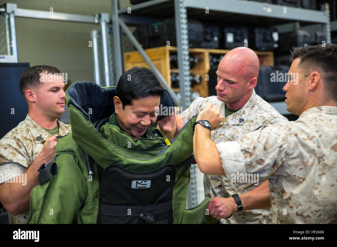 Royal Thai Armed Forces Lt. Gen. Krisda Norapoompipat, second from left, tries on an advanced bomb suit as U.S. Marines secure the outer armor May 19 at Camp Hansen. Norapoompipat visited Camp Hansen to discuss explosive ordnance disposal tactics, techniques and procedures employed by the U.S. Marine Corps, as well as both countries' capabilities for unexploded ordnance disposal training. The Kingdom of Thailand shares a long-standing alliance with the U.S., and both countries frequently work together in humanitarian aid efforts, preparation and training exercises. Norapoompipat is the directo Stock Photo