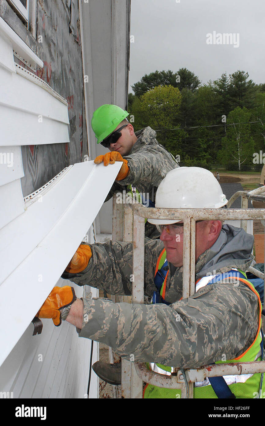 Staff Sgt. Kevin Burch and Senior Airman Mark Wilinski remove siding