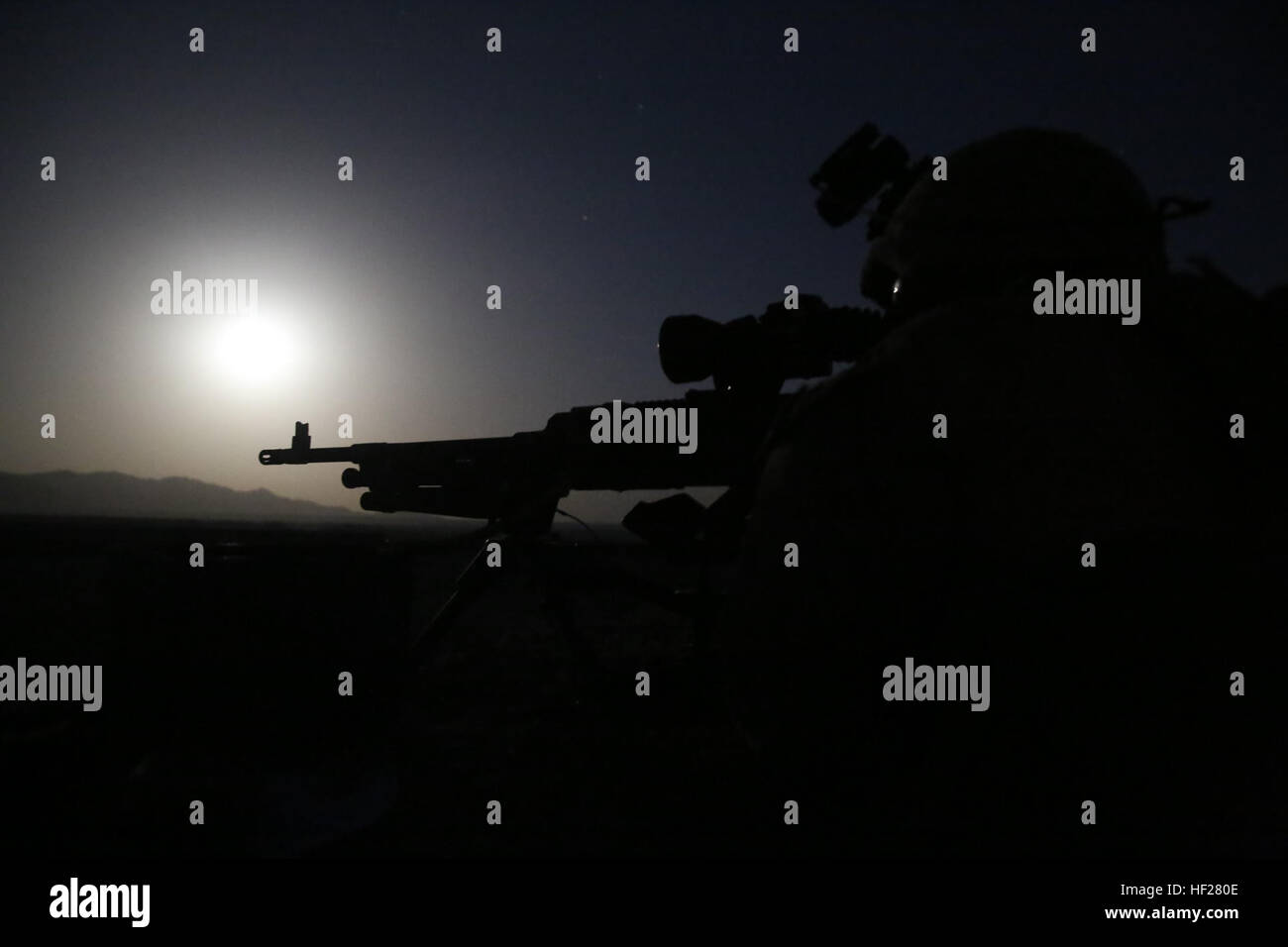 Lance Cpl. Alan Revilla, machine gunner, Weapons Company, 1st Battalion, 7th Marine Regiment, mans a M240B medium machine gun throughout the night from a security post during a mission in Helmand province, Afghanistan, June 13, 2014. Revilla, a native of Houston, along with a platoon of infantrymen, provided security at Patrol Base Ouellette, an Afghan National Army controlled-base, during the Afghanistan presidential runoff elections. While International Security Assistance Force stood ready to support as needed, the elections were entirely Afghan led and Afghan conducted. Infantrymen stand b Stock Photo